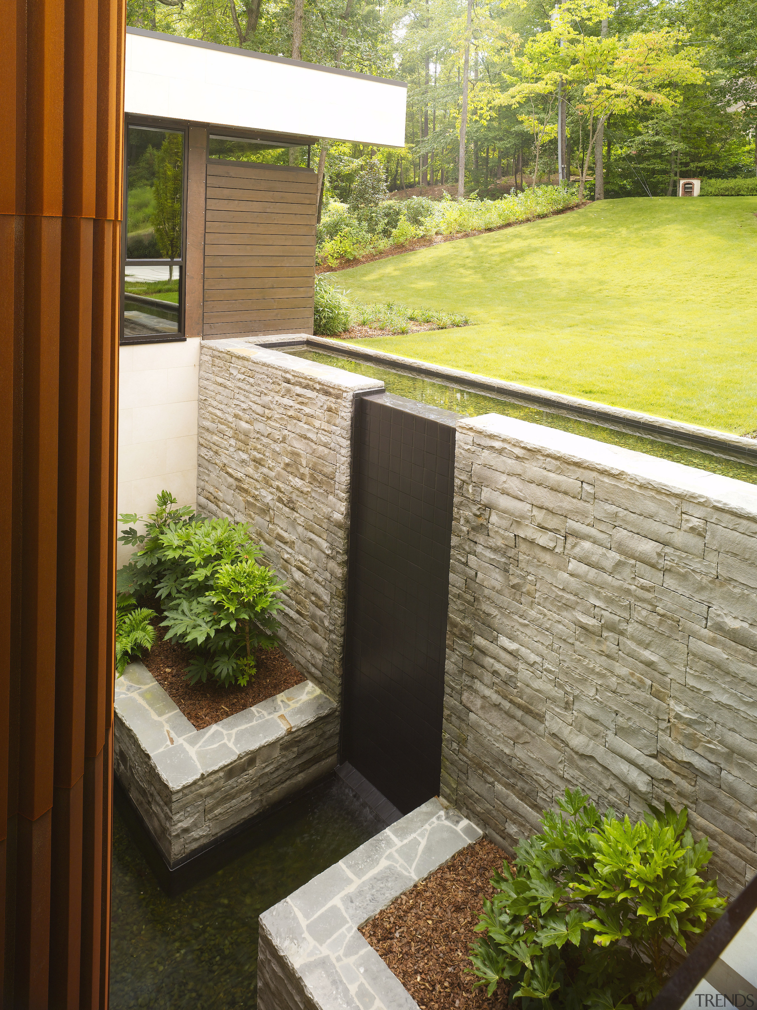 Above: A bridge to the front door of architecture, backyard, courtyard, garden, grass, home, house, landscaping, lawn, outdoor structure, plant, real estate, wall, window, yard, brown