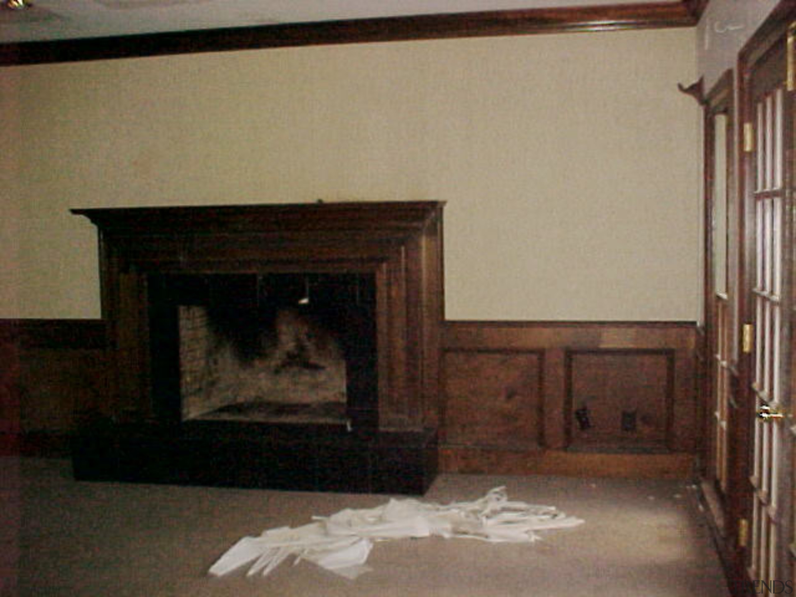 Compartmentalized rooms were merged to create a large fireplace, floor, flooring, furniture, hearth, home, house, room, wood, brown