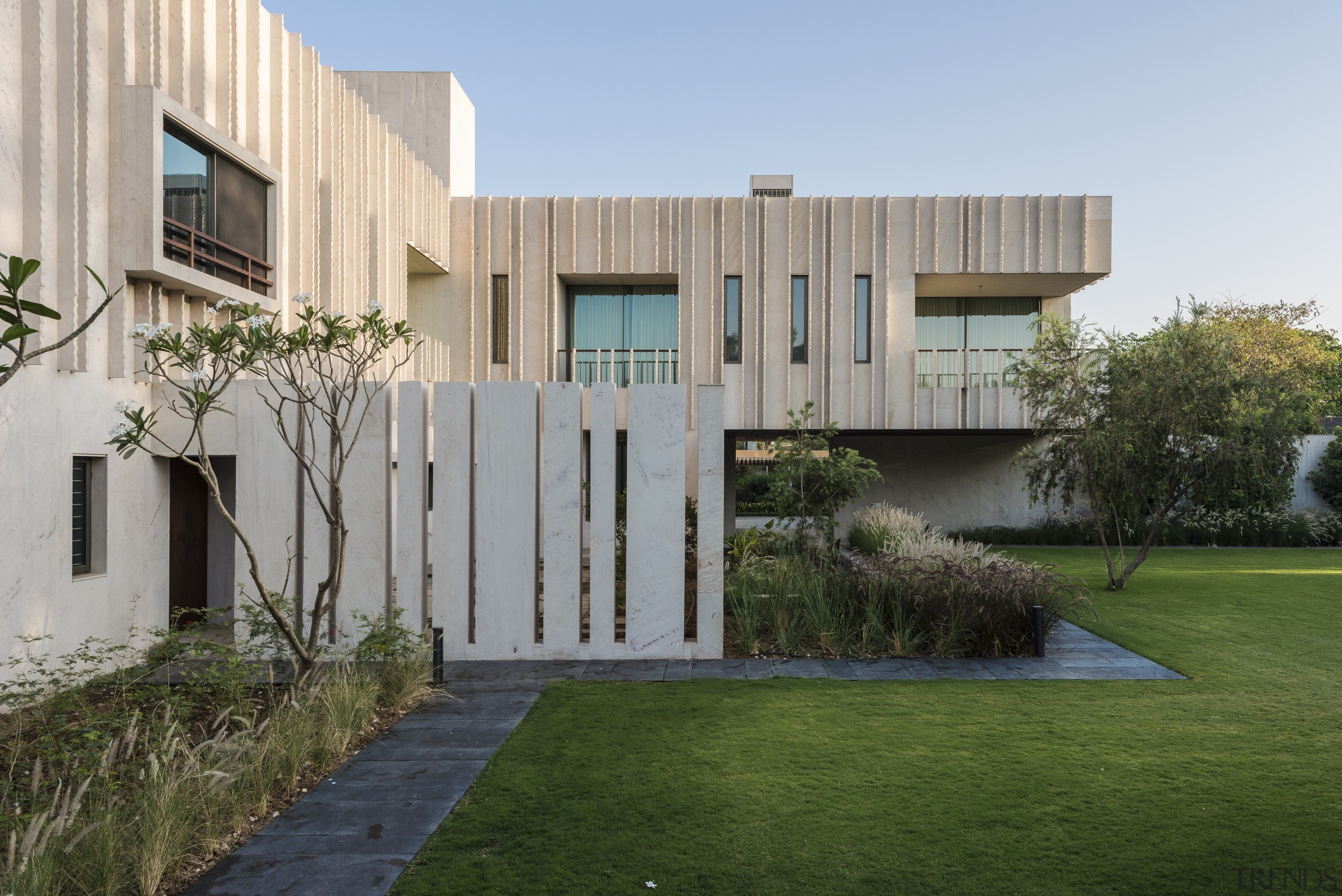 The stone blades protruding from the cladding create apartment, architecture, backyard, building, courtyard, estate, facade, grass, home, house, interior design, land lot, lawn, property, real estate, residential area, roof, room, tree, urban design, villa, yard, gray, brown