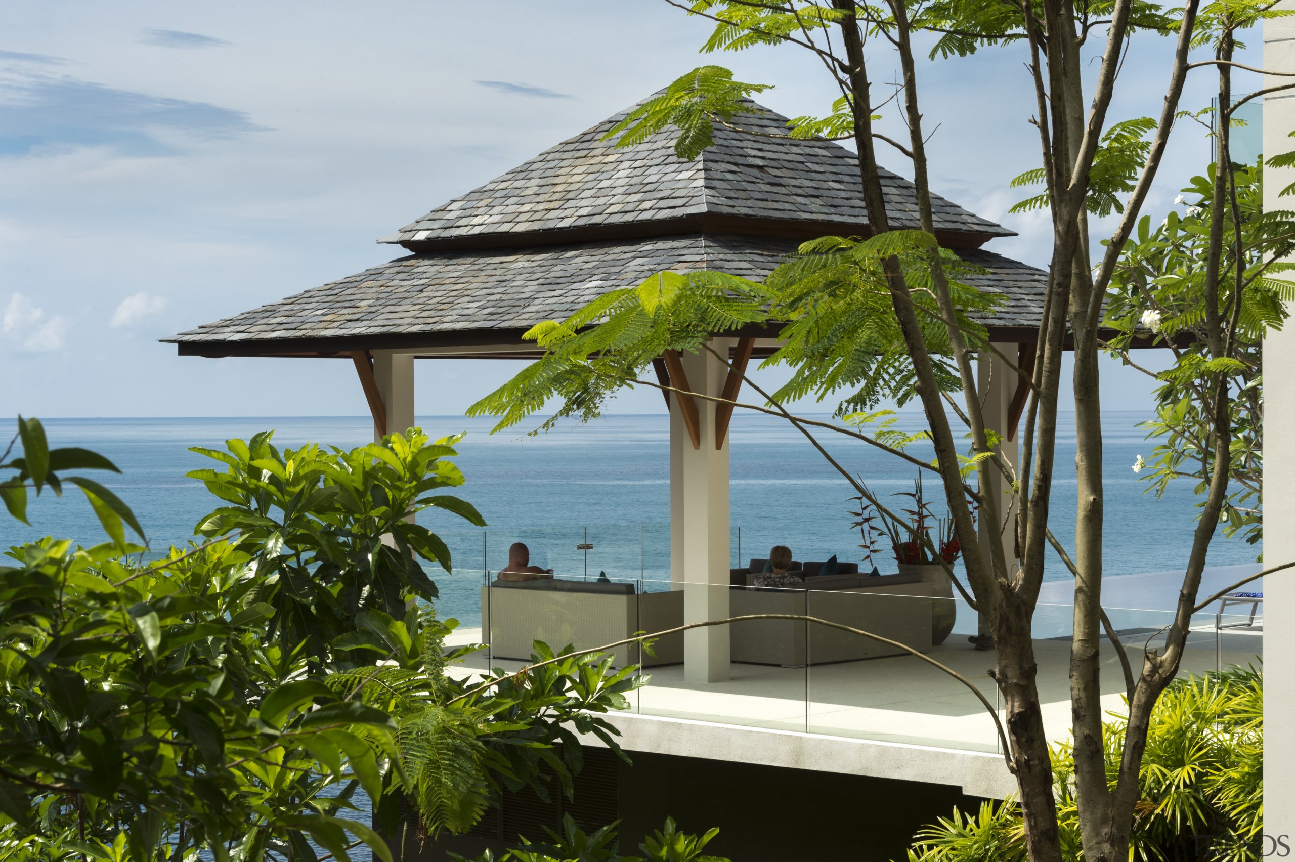 A Thai sala  a roofed pavilion with arecales, house, outdoor structure, palm tree, plant, real estate, resort, roof, tree, tropics, vacation, brown, gray