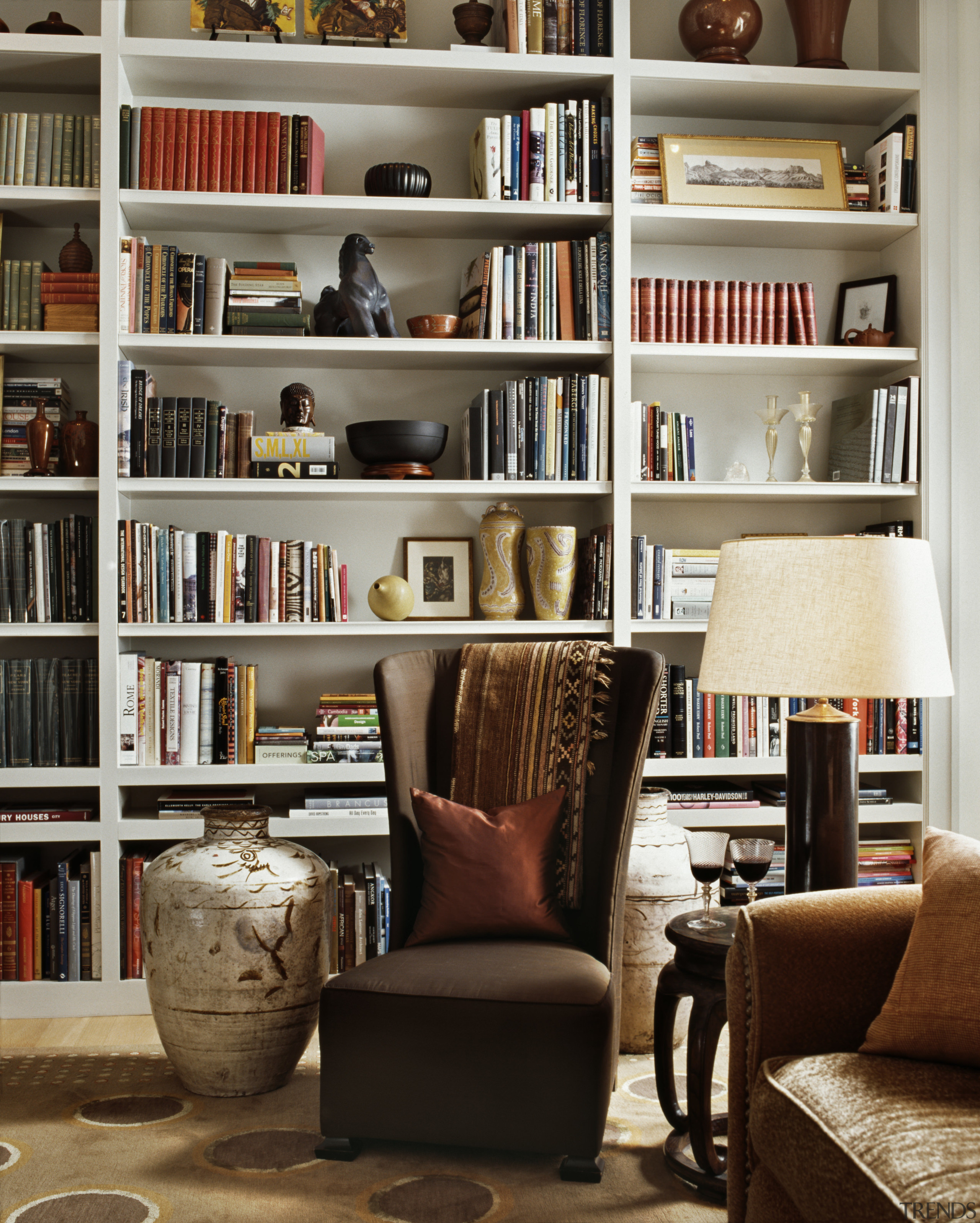 view of a living area which features shelving bookcase, chair, furniture, home, interior design, library, living room, public library, shelf, shelving, brown