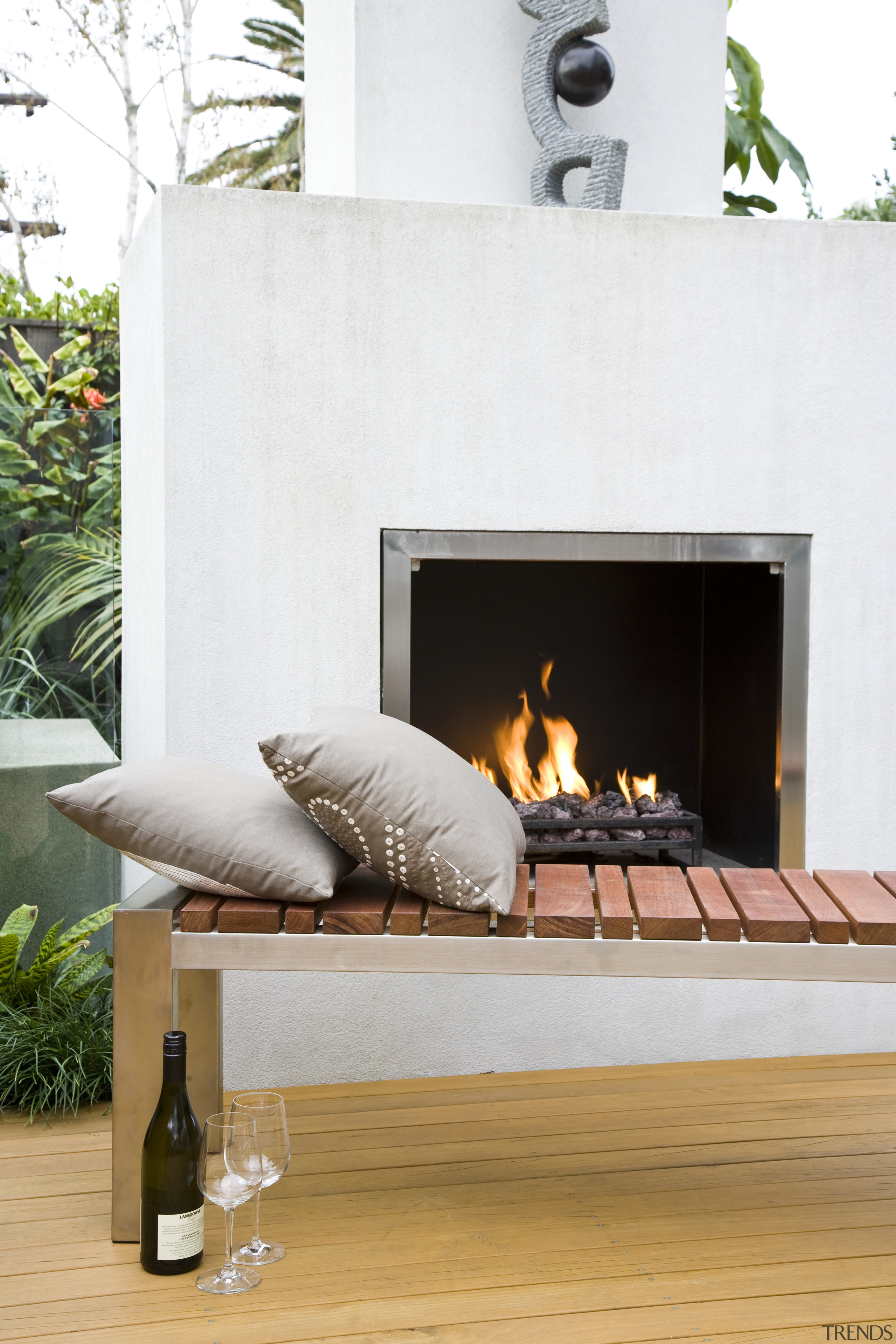 View of outdoor entertaining area which features a fireplace, furniture, hearth, heat, table, wood burning stove, white