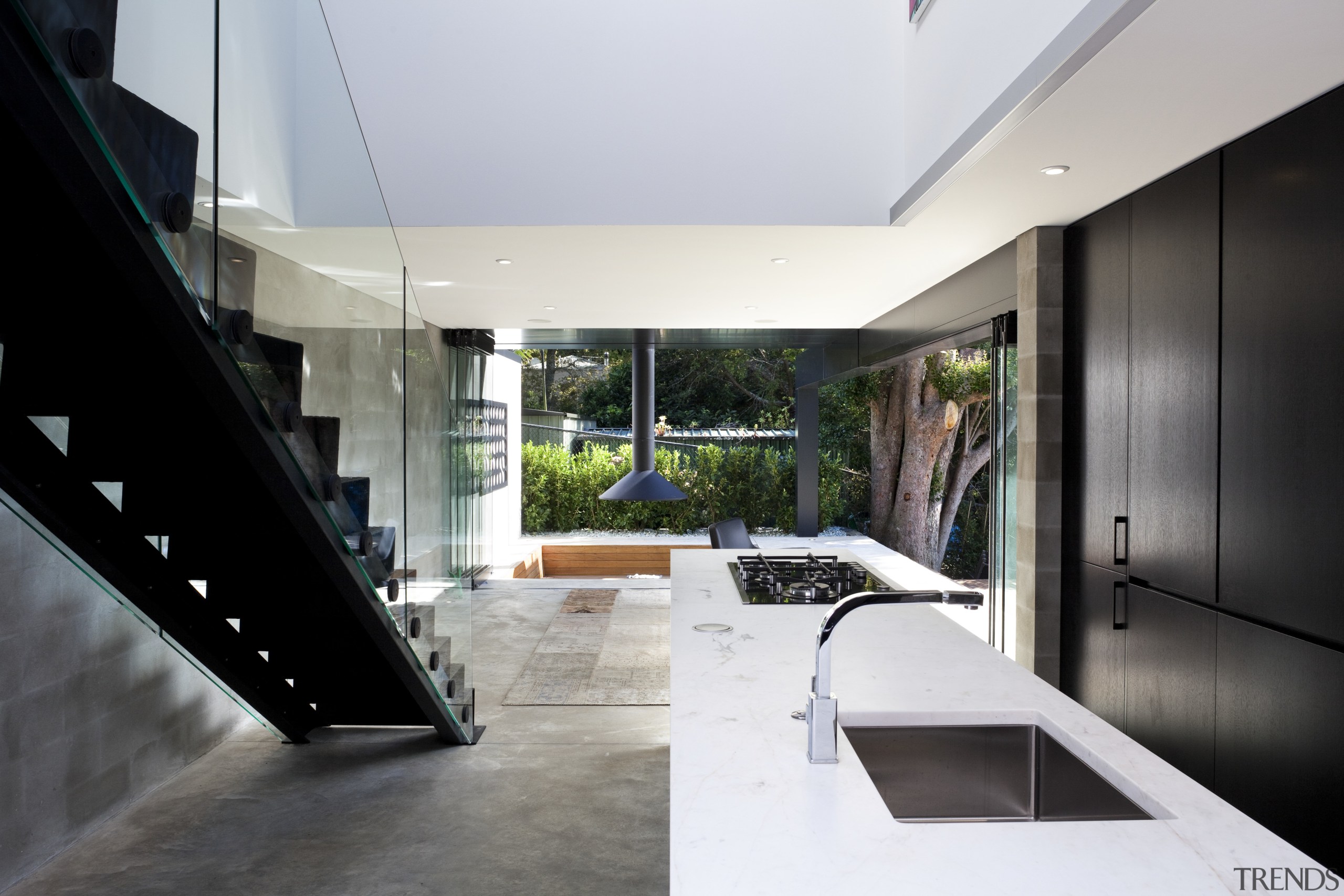 Kitchen near stairs. White countertop, black cabinetry. See architecture, house, interior design, white, black