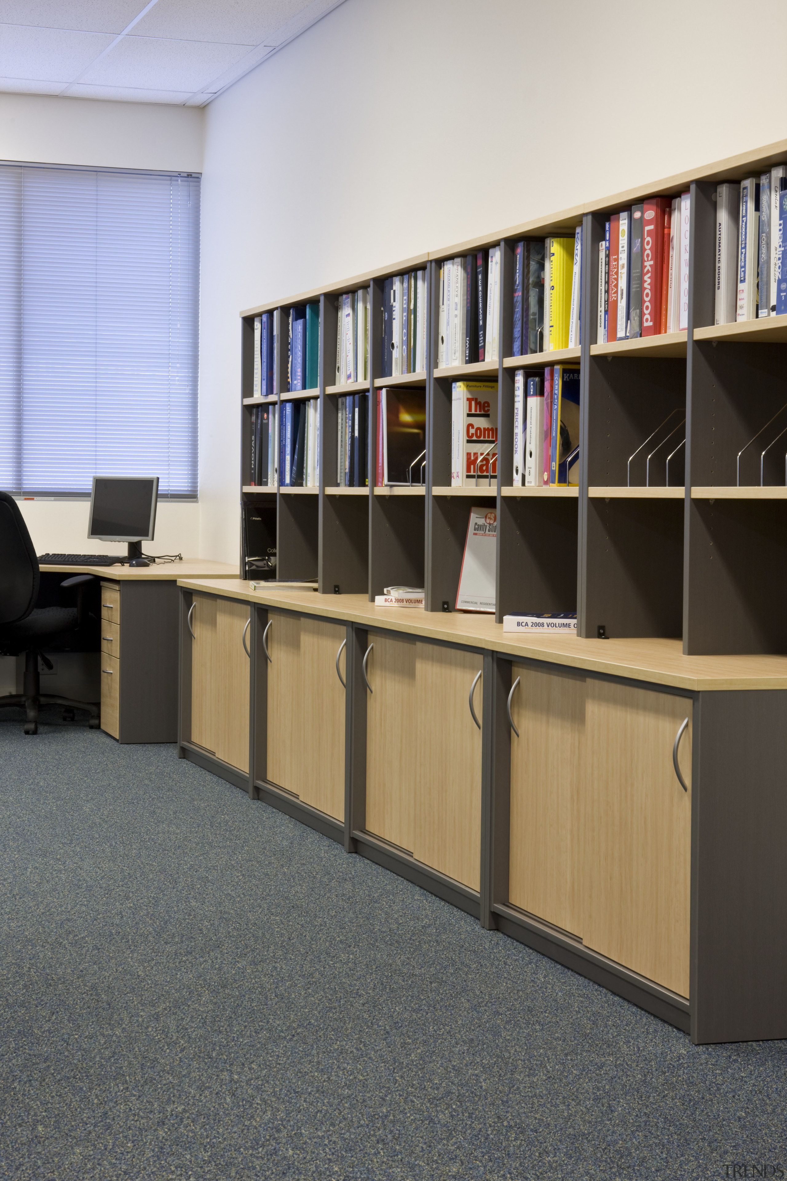 Image of desk and shelving supplied by The bookcase, floor, flooring, furniture, institution, library, library science, public library, shelf, shelving, black