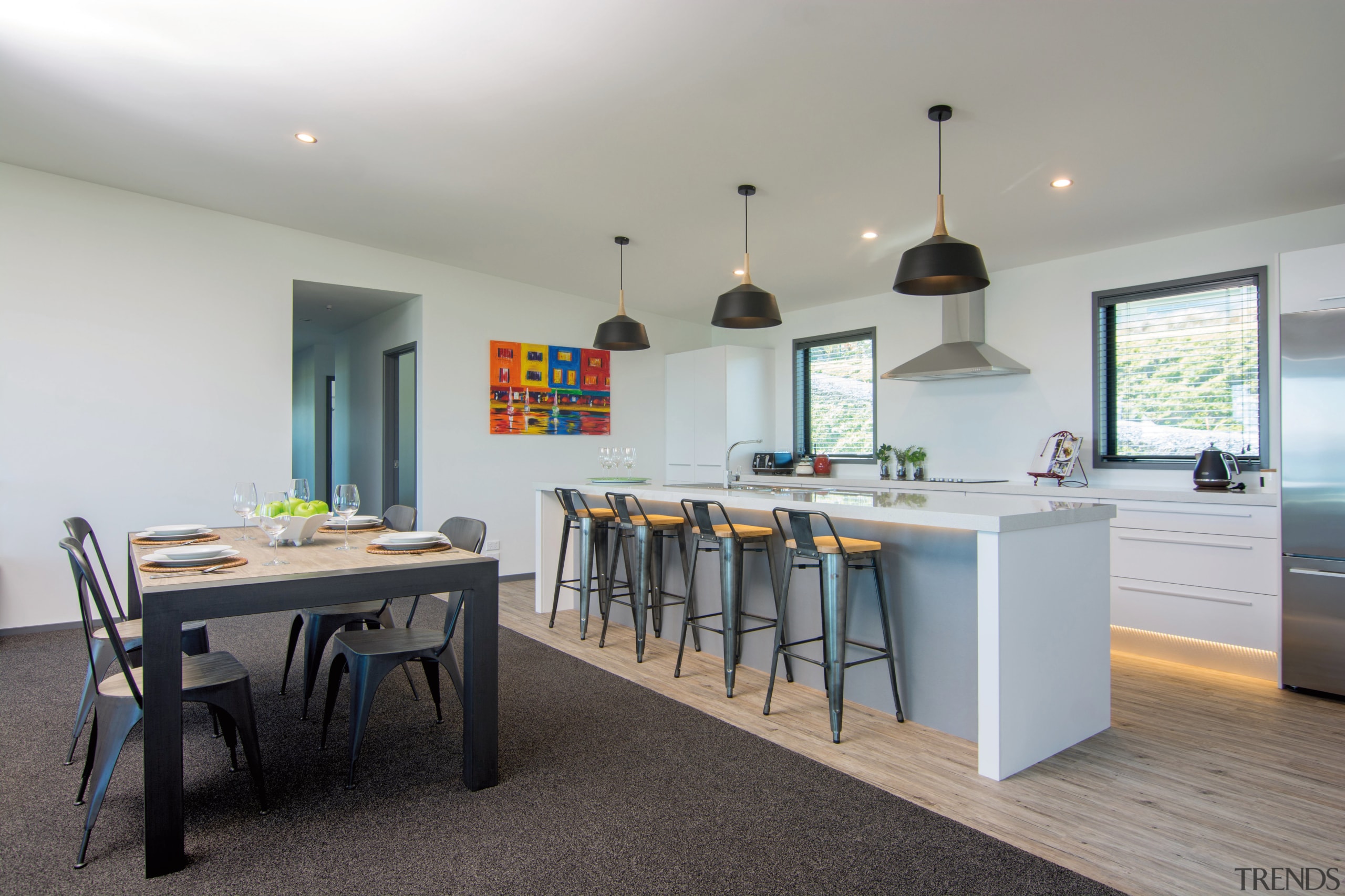 Thick, warm-toned carpet meets hard-wearing vinyl planking, demarcating countertop, dining room, interior design, kitchen, real estate, room, table, gray