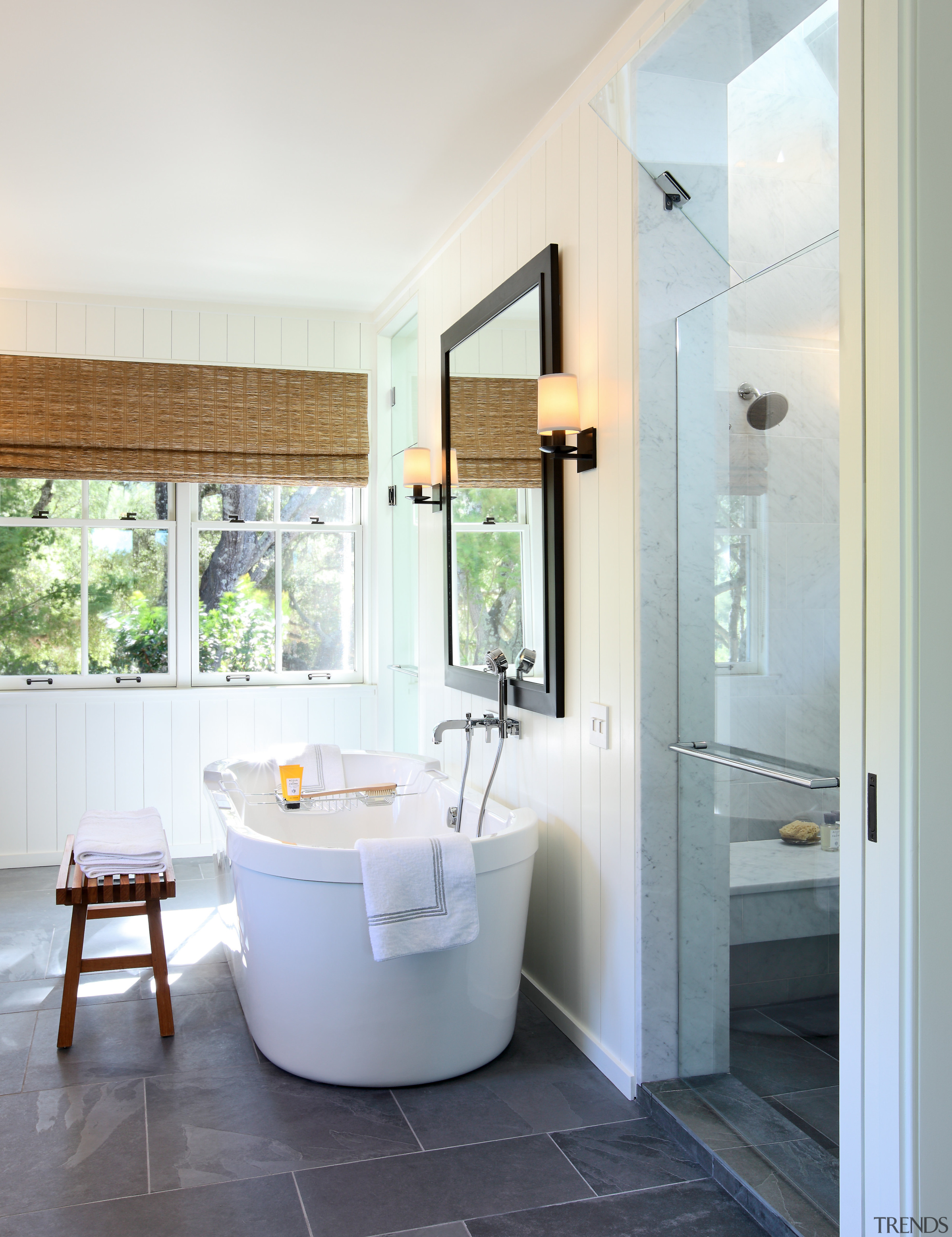 Bathroom with grey tiled flooring and white tub. bathroom, floor, home, interior design, plumbing fixture, real estate, room, window, white