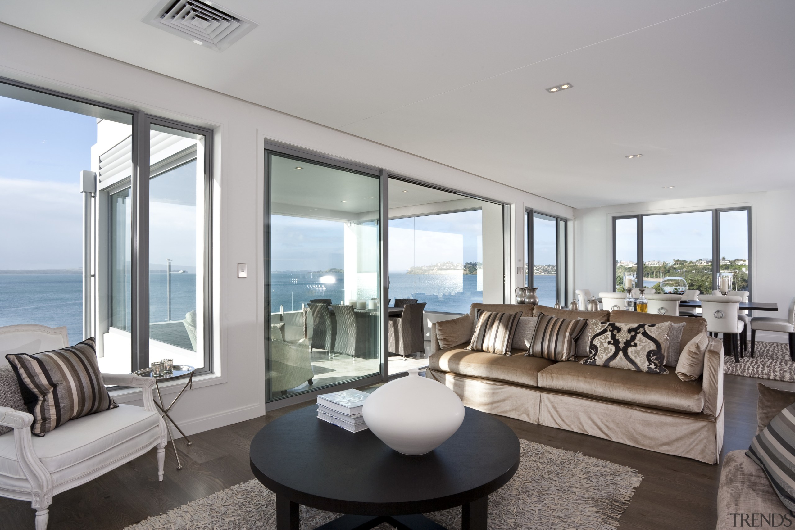 View of lounge featuring sofas, oak floors, rug, apartment, condominium, home, house, interior design, living room, penthouse apartment, property, real estate, window, gray