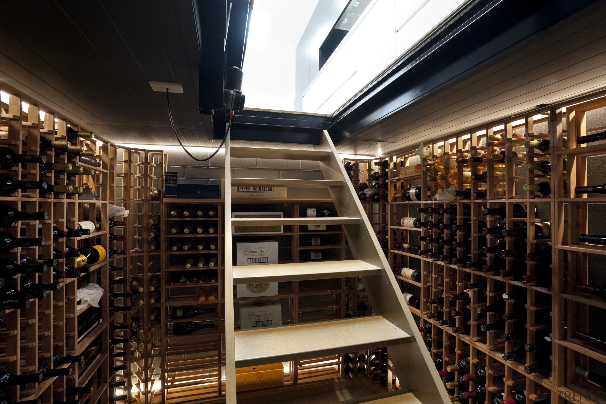 This fully lined basement wine cellar is accessed library, liquor store, wine cellar, winery, black