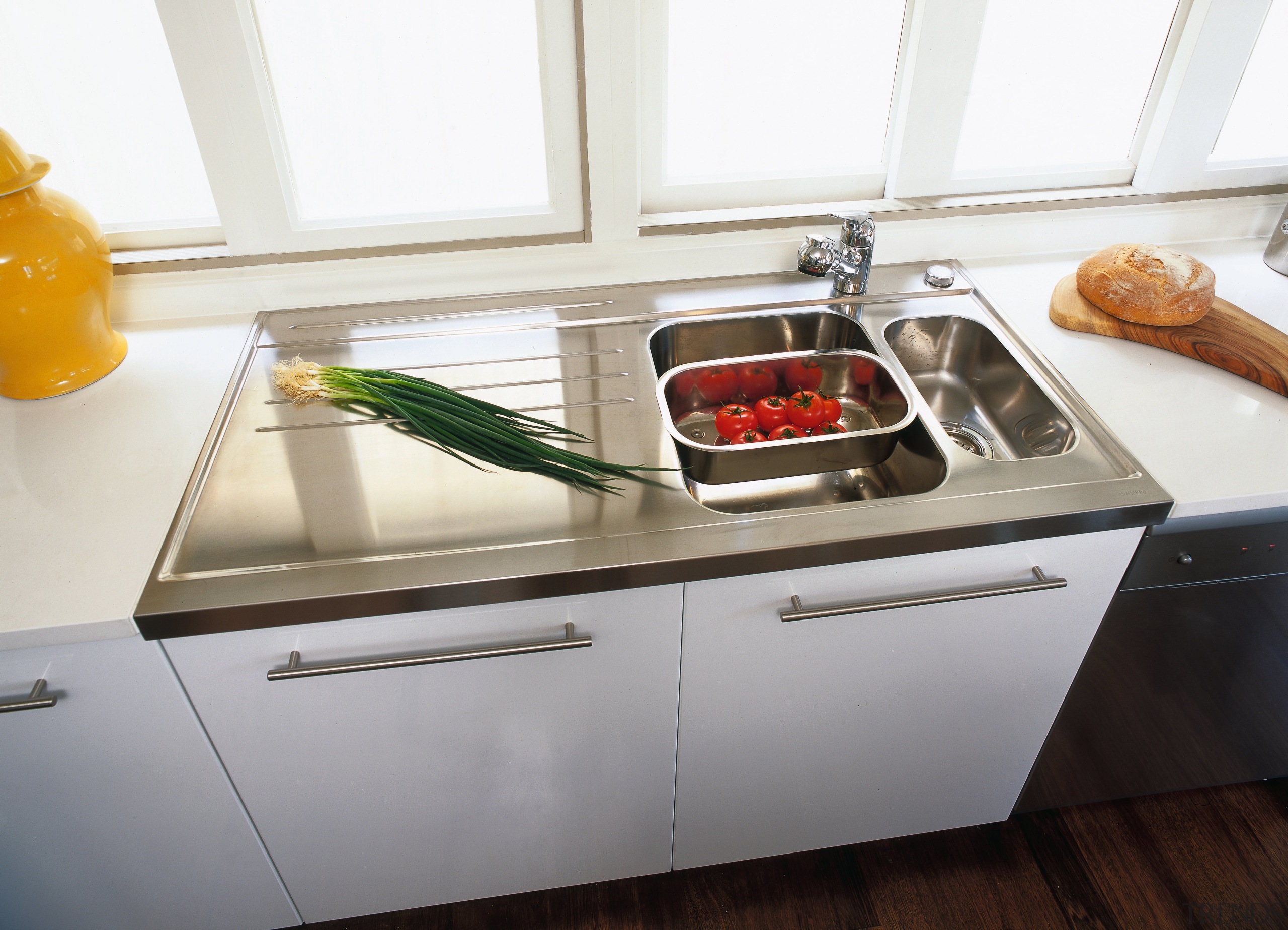 A view of akitchen area, wooden flooring, white cookware and bakeware, countertop, home appliance, kitchen, kitchen appliance, kitchen stove, sink, small appliance, tap, white