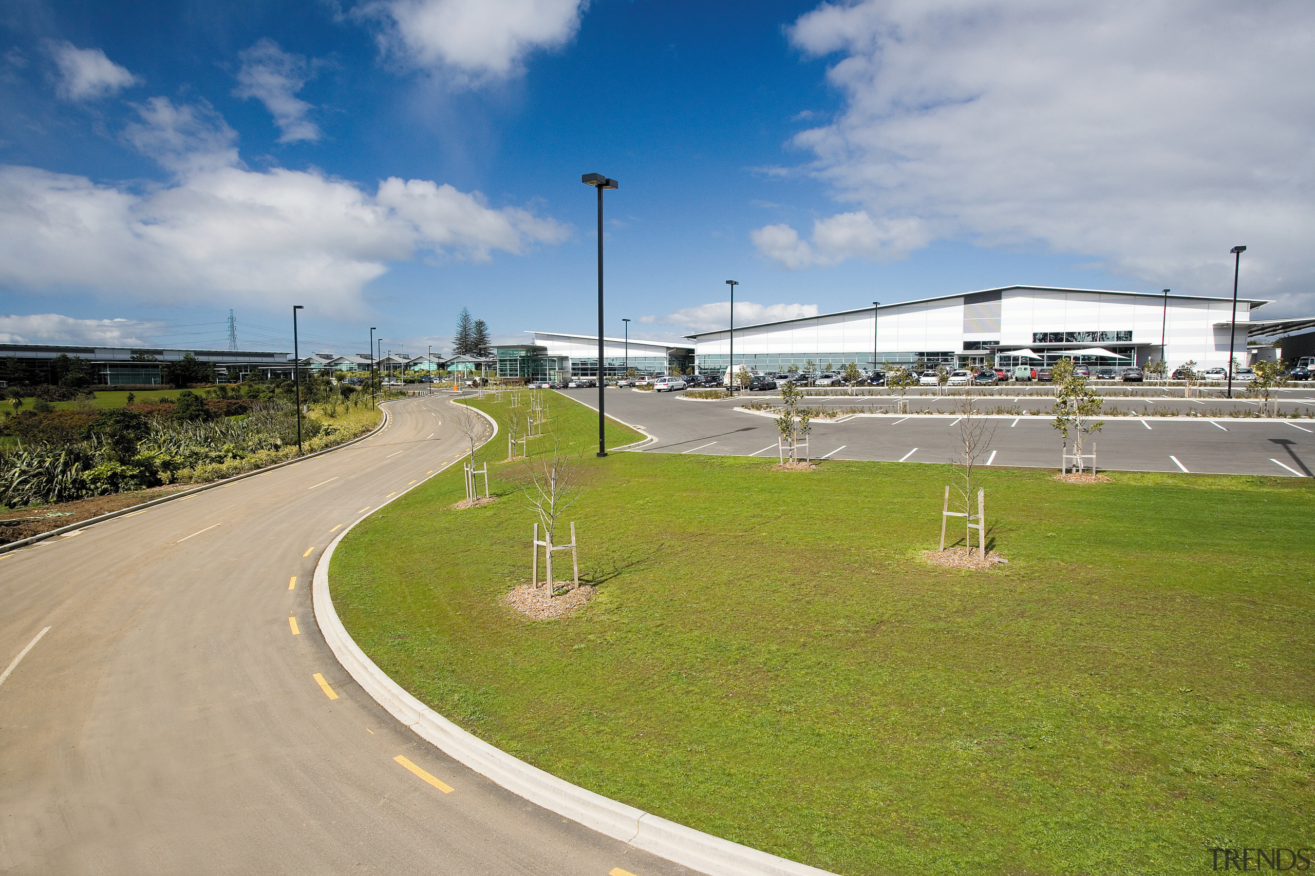 A view of the building and man made asphalt, cloud, grass, infrastructure, race track, road, sky, sport venue, structure, tree, gray