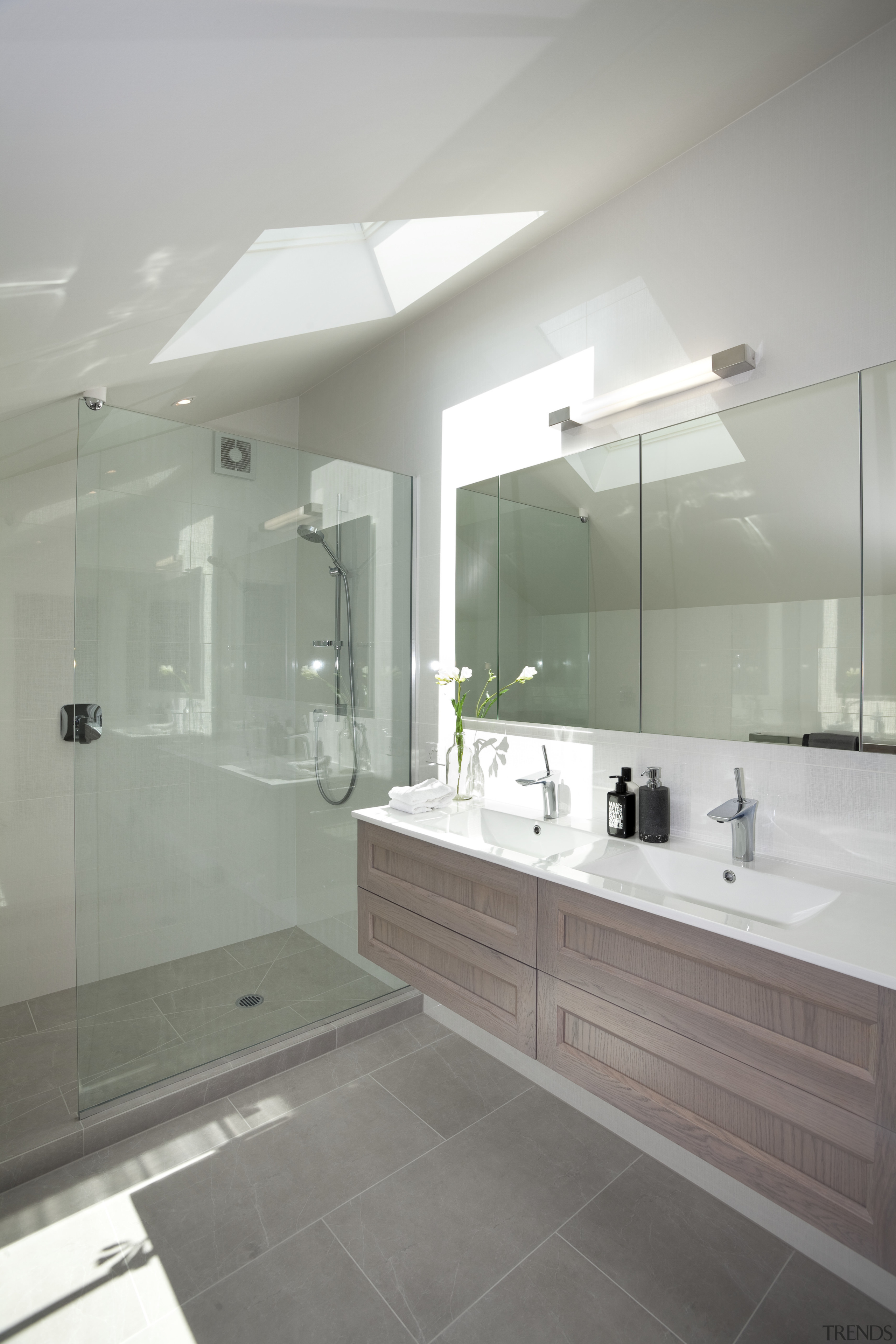 The master bathroom of this remodelled villa features architecture, bathroom, bathroom accessory, bathroom cabinet, floor, glass, home, interior design, plumbing fixture, room, sink, tap, tile, gray