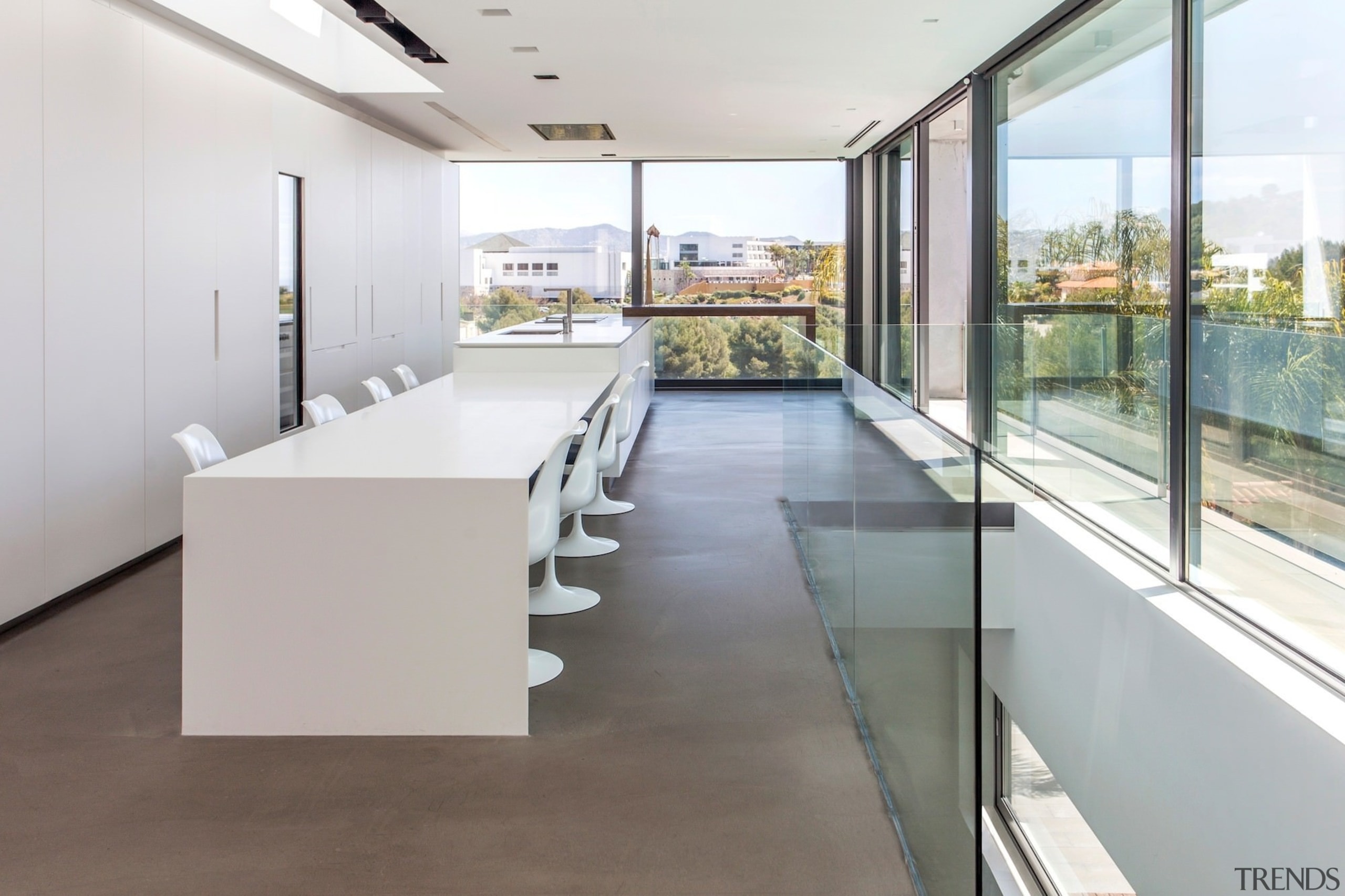 The kitchen island flows down onto a dining floor, flooring, glass, house, interior design, real estate, gray, white