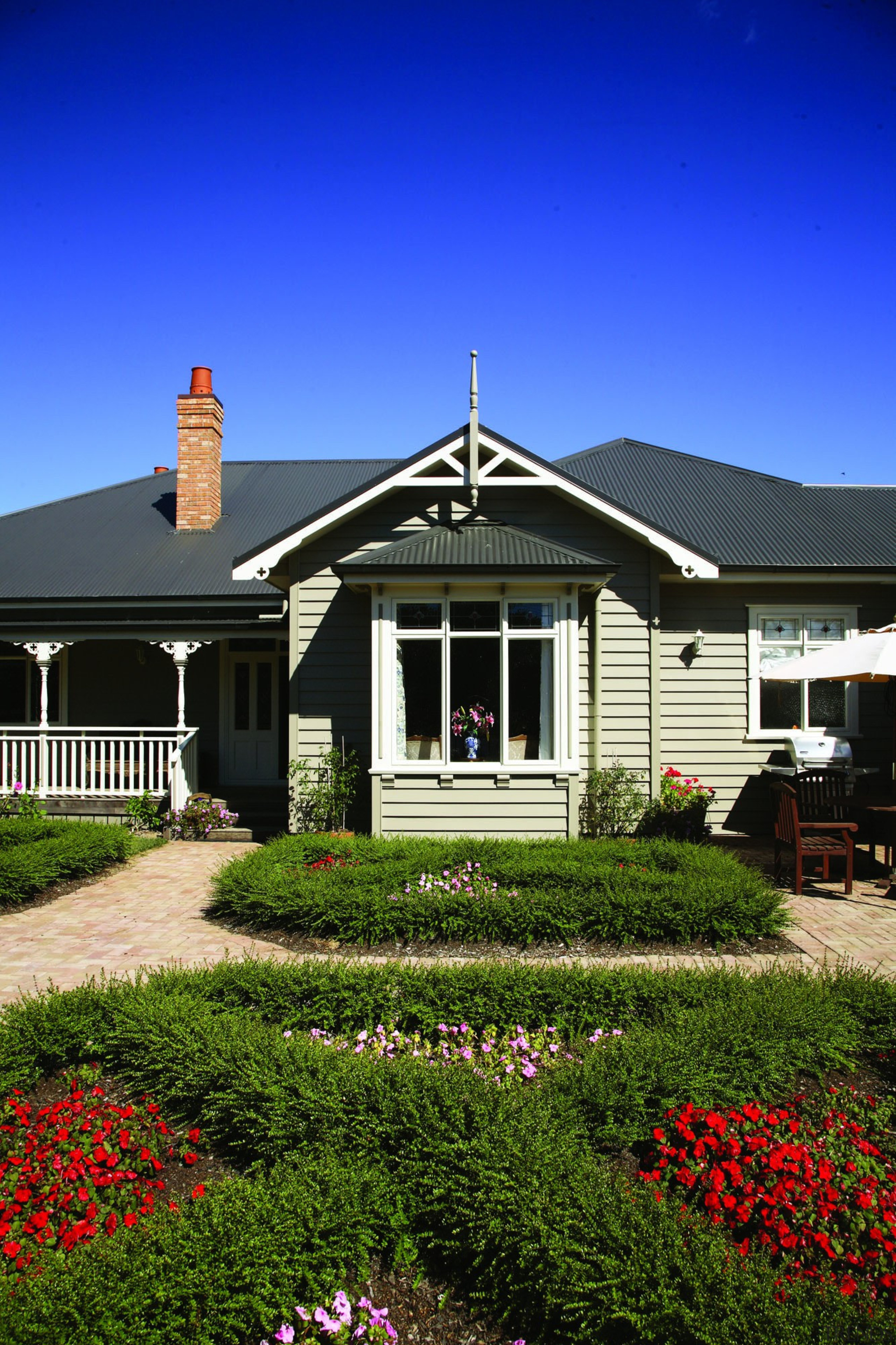 Enchanting Villa - Corrugate Iron Sand - Exterior cottage, elevation, estate, facade, farmhouse, grass, home, house, landscape, landscaping, mansion, property, real estate, residential area, roof, siding, sky, suburb, window, blue