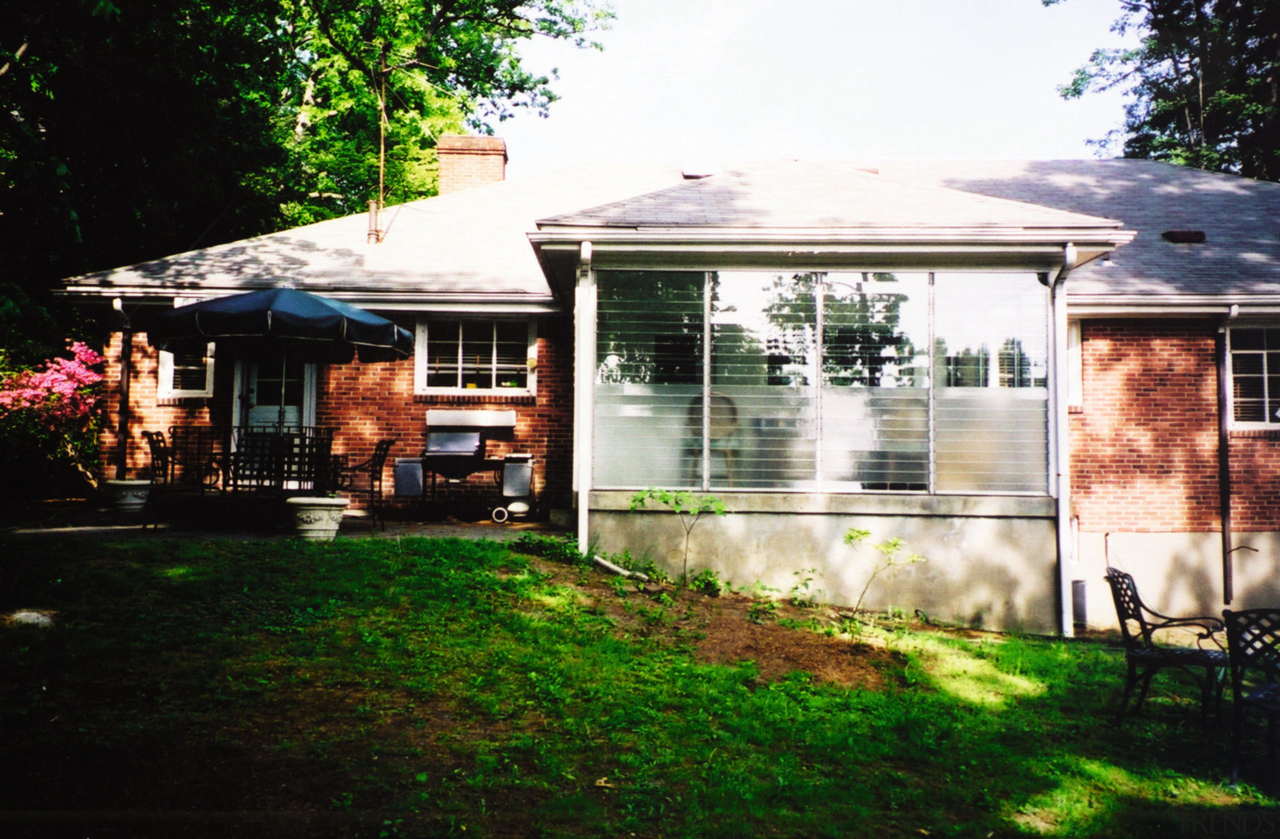 as the enclosed porch at the rear was backyard, cottage, home, house, lighting, outdoor structure, porch, property, real estate, residential area, roof, shed, siding, tree, window, yard, black, white