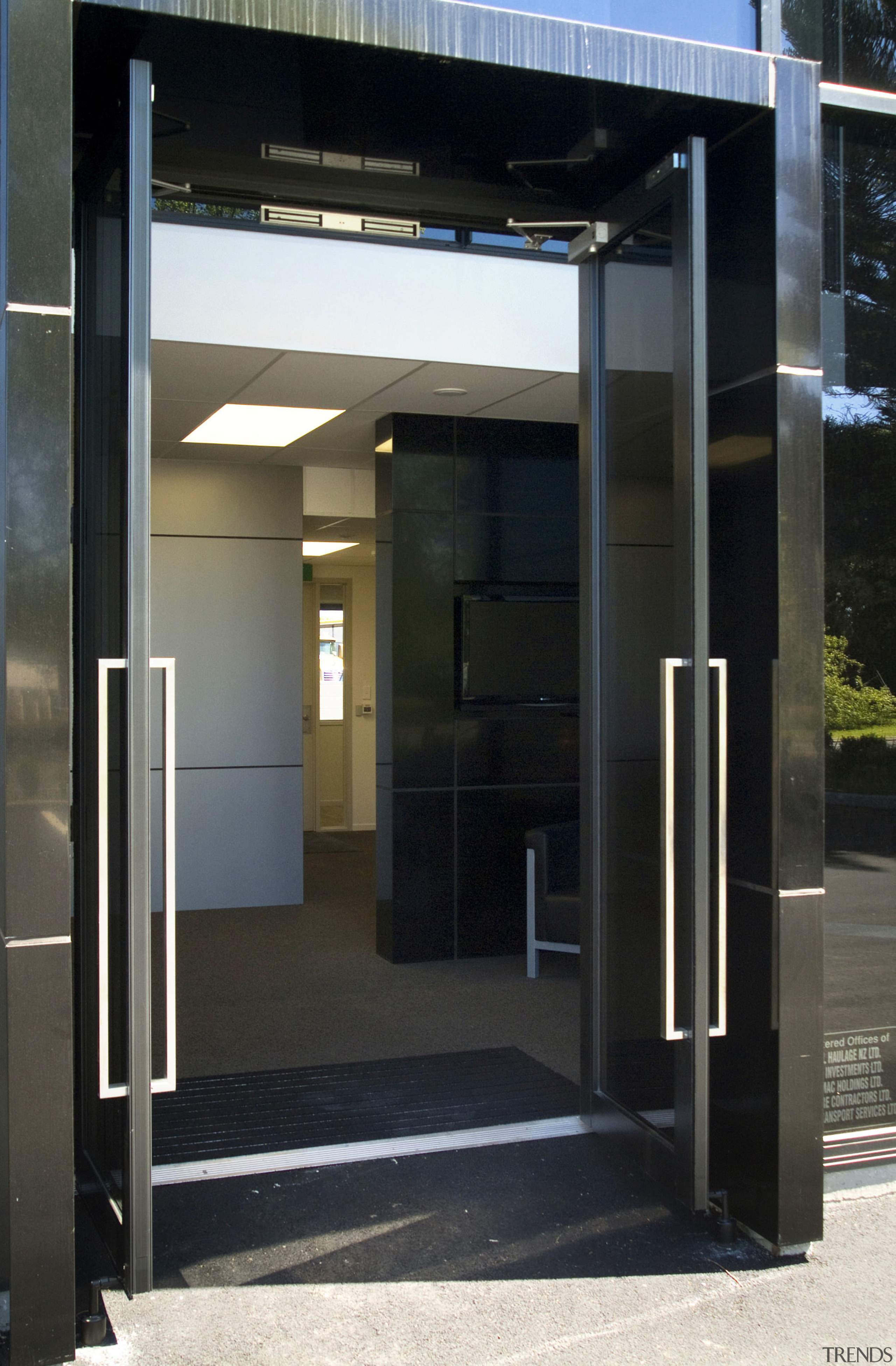 Close-up of the main entrance way which features architecture, door, glass, black