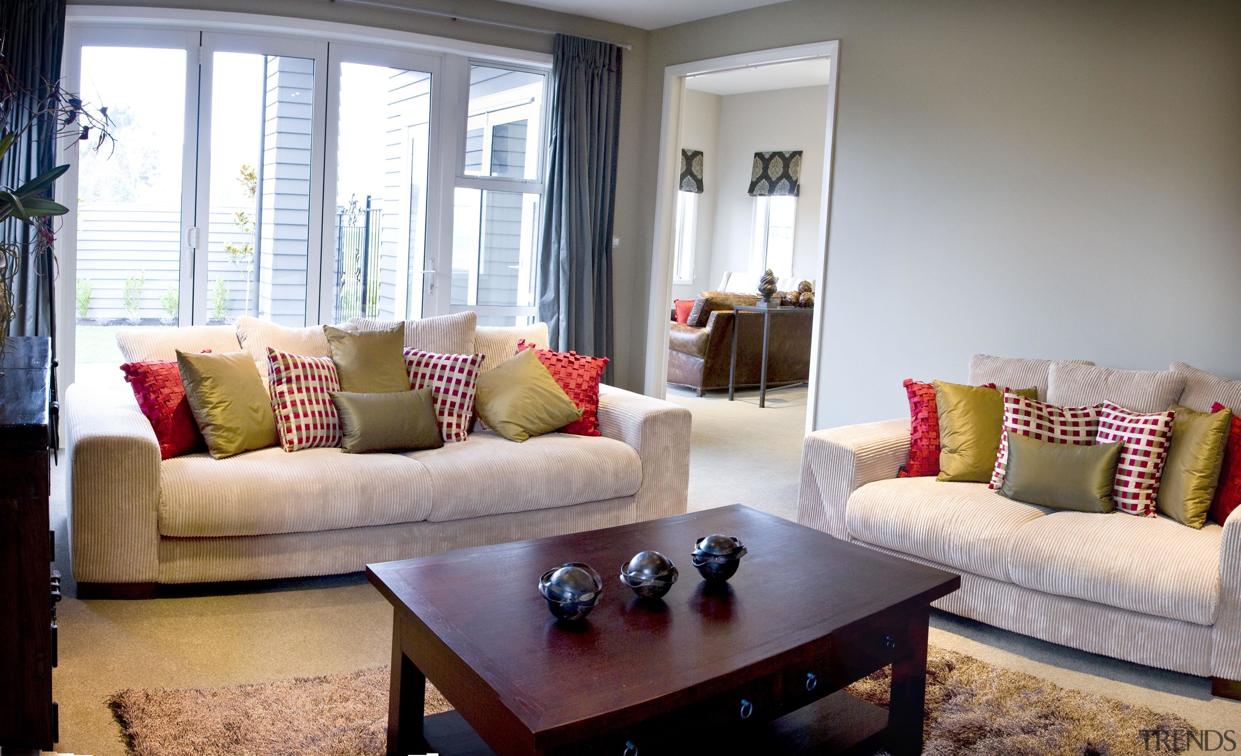 Bright lounge with red and green colored accessories couch, furniture, home, interior design, living room, property, real estate, room, table, window, window covering, window treatment, gray