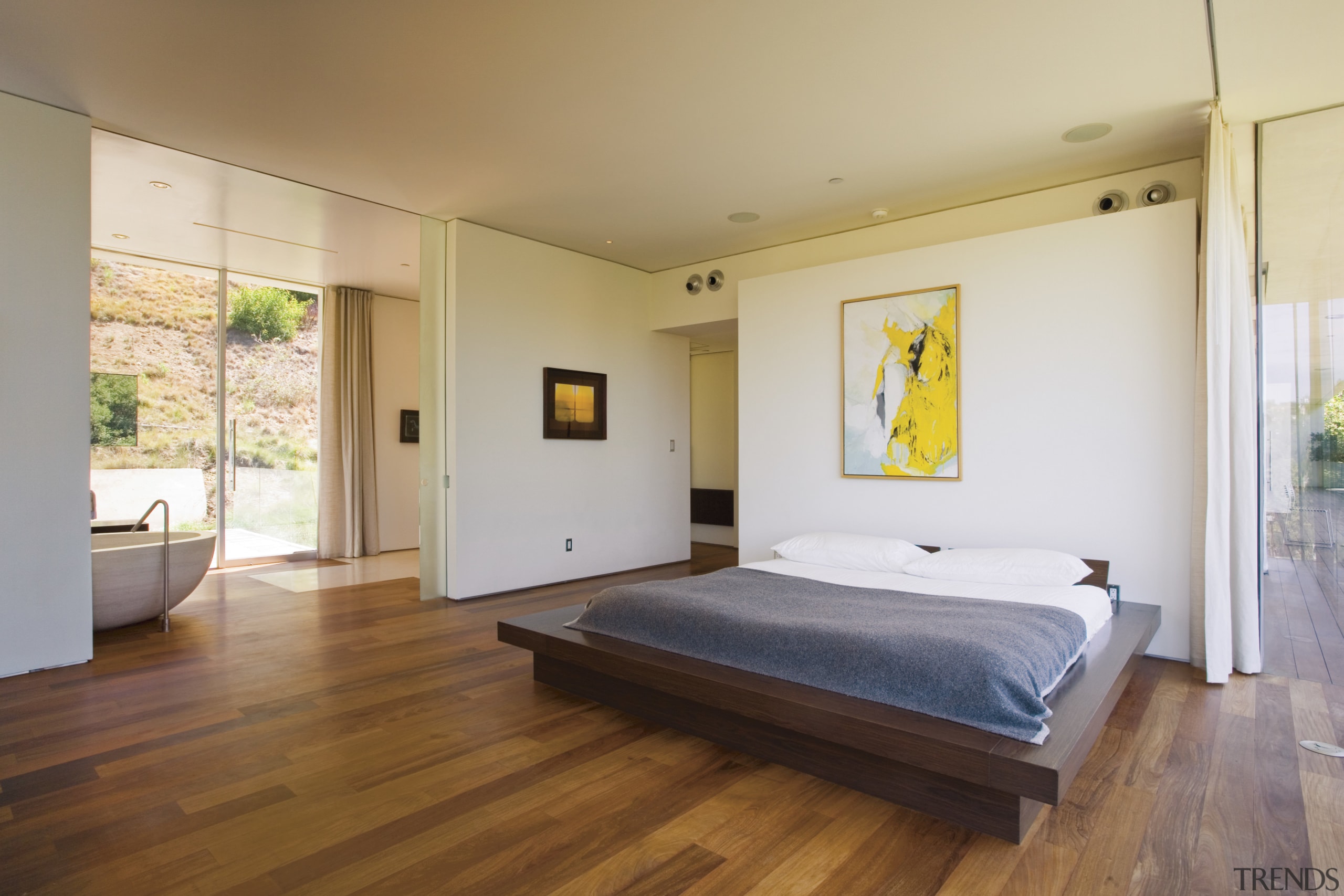 A view of this master bedroom featuring brazilian architecture, bed, bed frame, bedroom, ceiling, estate, floor, flooring, hardwood, house, interior design, laminate flooring, property, real estate, room, wood, wood flooring, gray, brown