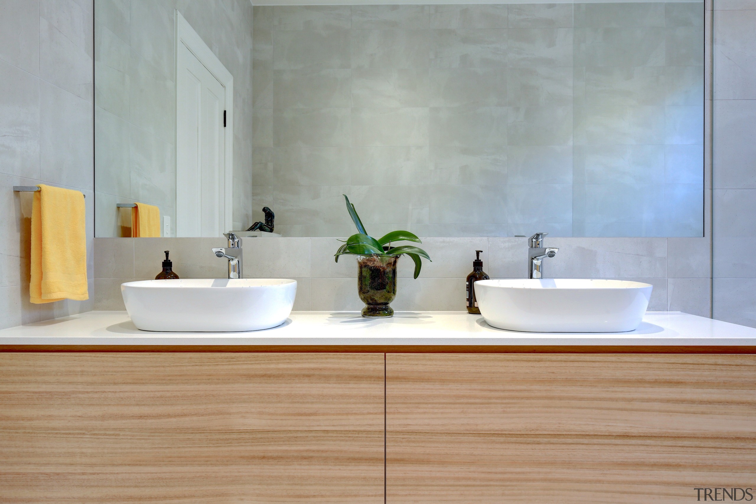 A large mirror was a key part of architecture, bathroom, bathroom sink, ceramic, countertop, floor, flooring, hardwood, interior design, marble, material property, plumbing fixture, property, room, sink, tap, tile, wall, wood, gray