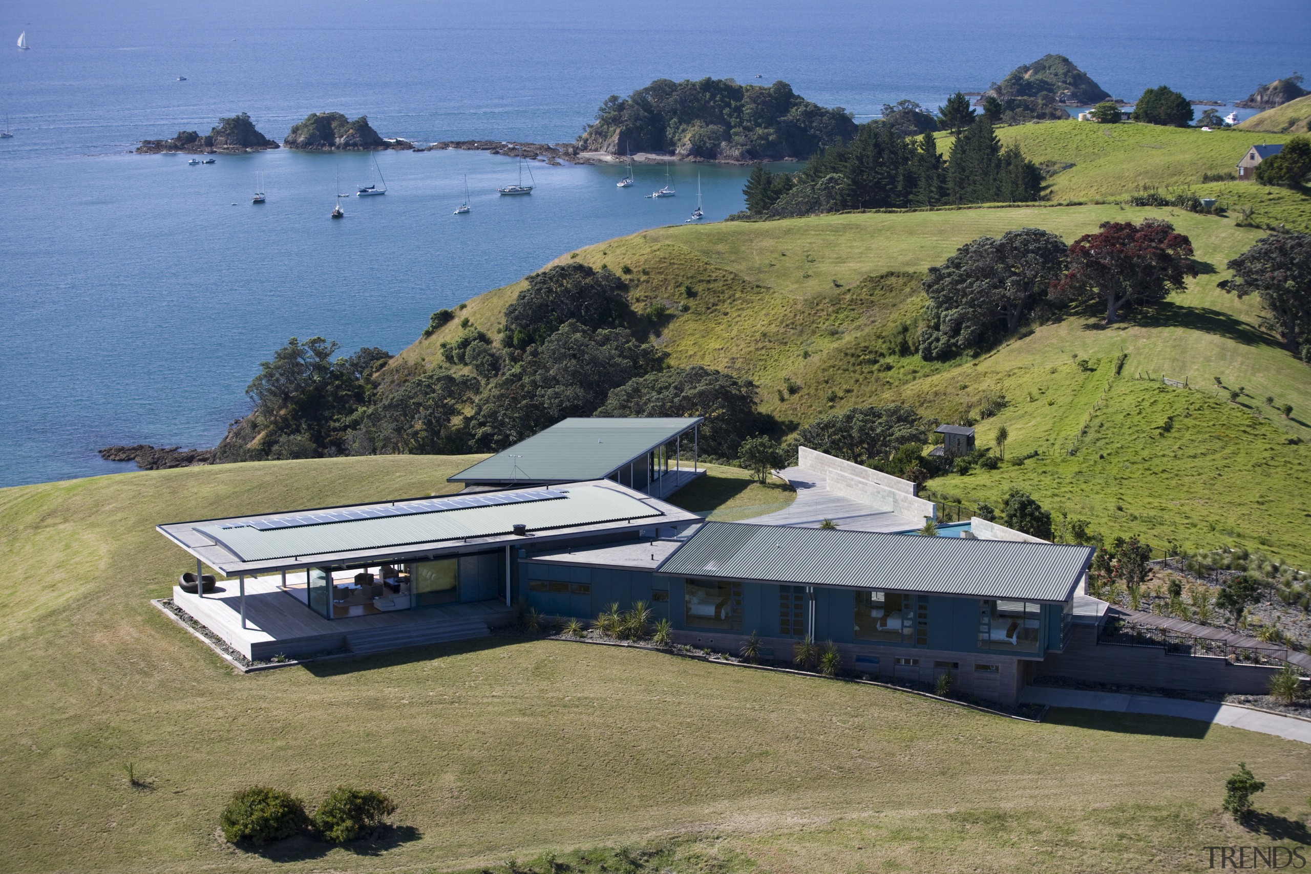 Image of the exterior of this beautifully designed aerial photography, bay, coast, cottage, estate, home, house, promontory, property, real estate, sea, terrain, brown, teal