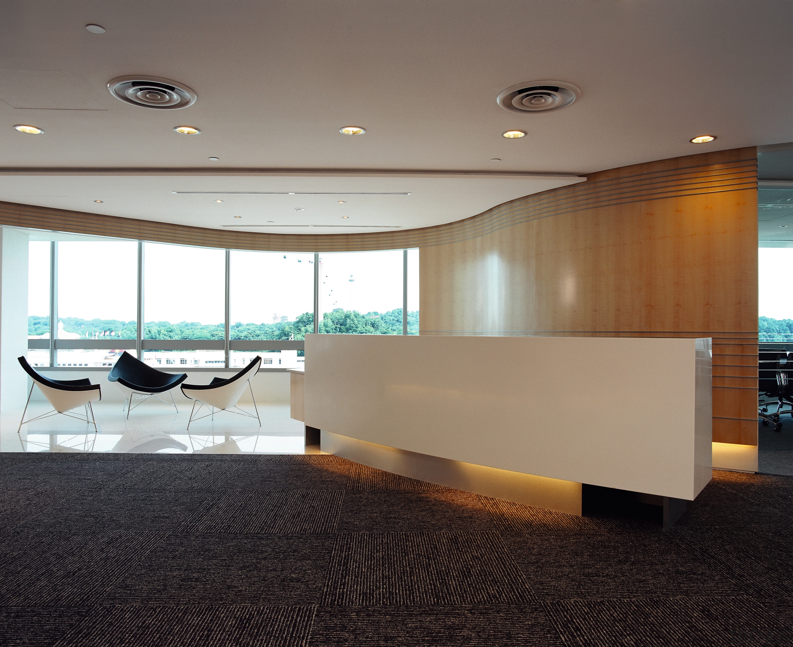 Office reception area with cream front desk, wood architecture, ceiling, daylighting, floor, flooring, furniture, glass, interior design, lobby, table, gray, black