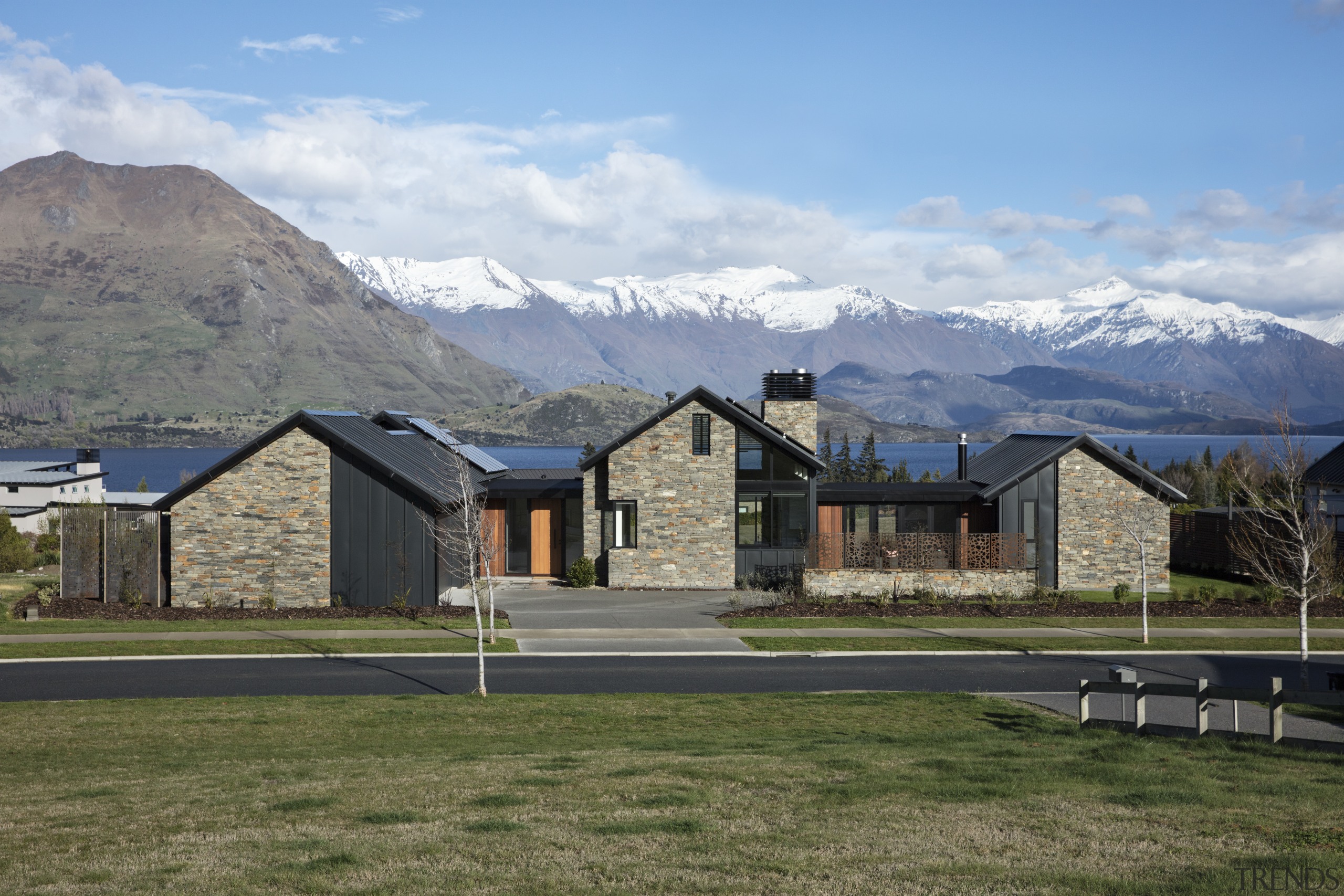 ​​​​​​​The triple peaks of this pavilion home by alps, highland, hill, home, house, andscape, roof, stone, timber, Condon Scott Architects, schist, cladding