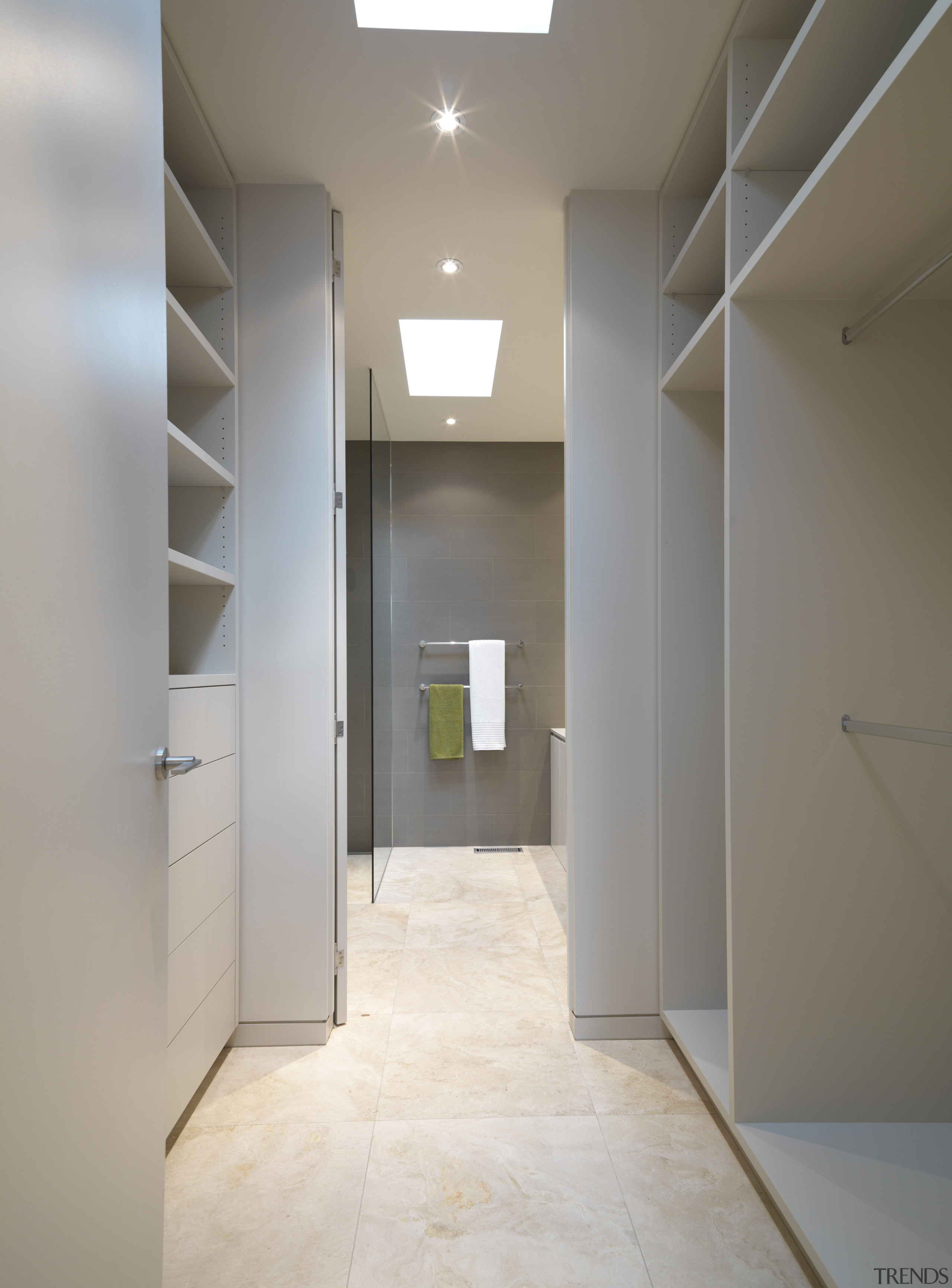 View of a walk-in closet which leads to apartment, architecture, ceiling, daylighting, floor, flooring, hall, home, house, interior design, lighting, property, real estate, room, wall, gray