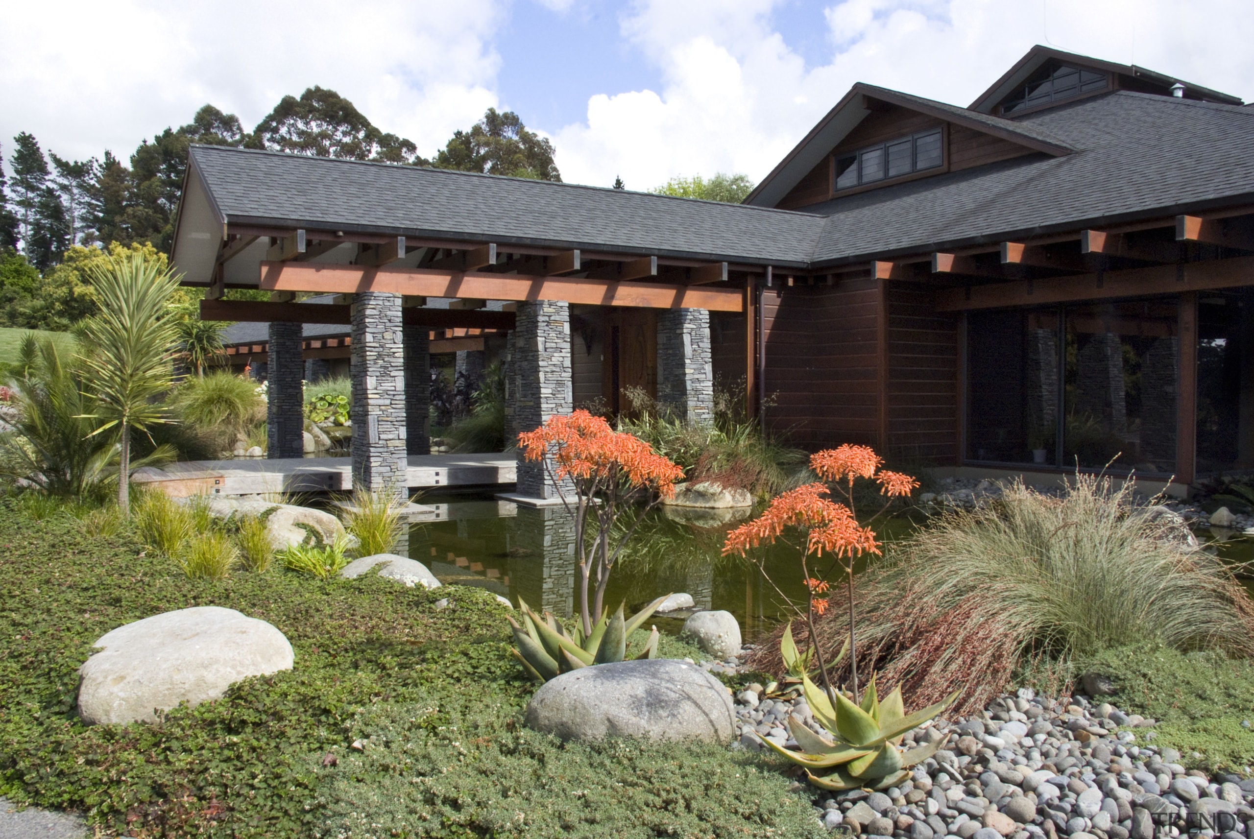 View of the entrance way which features schist backyard, cottage, estate, garden, home, house, landscape, landscaping, outdoor structure, plant, pond, property, real estate, yard