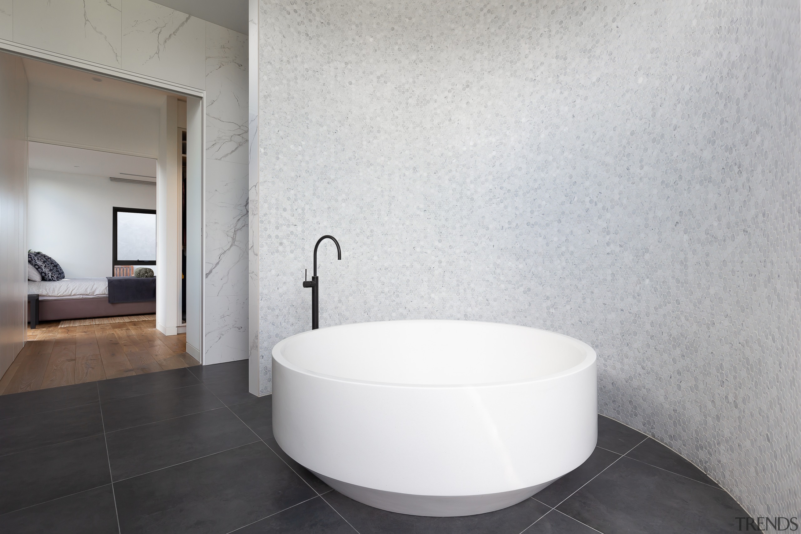 The feature curved wall in this master ensuite gray, white