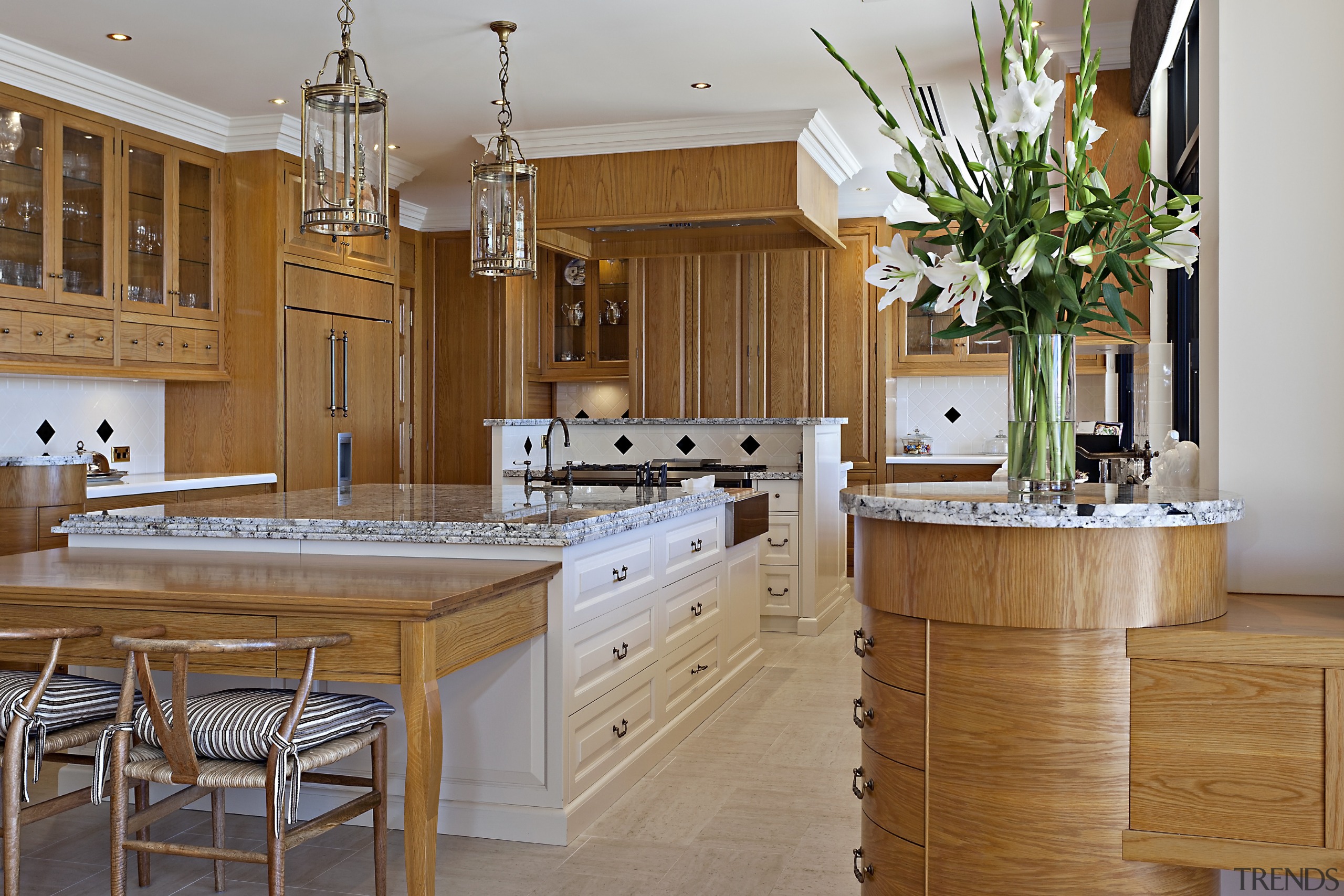 The larger island in this kitchen has an cabinetry, countertop, cuisine classique, interior design, kitchen, room, brown, gray