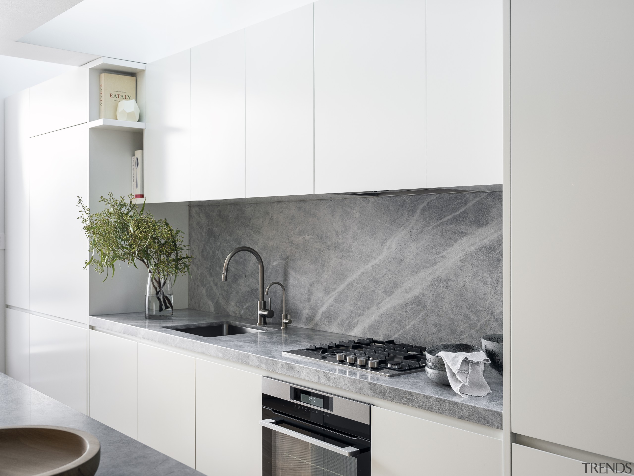 This white kitchen’s benchtops and splashback are in 