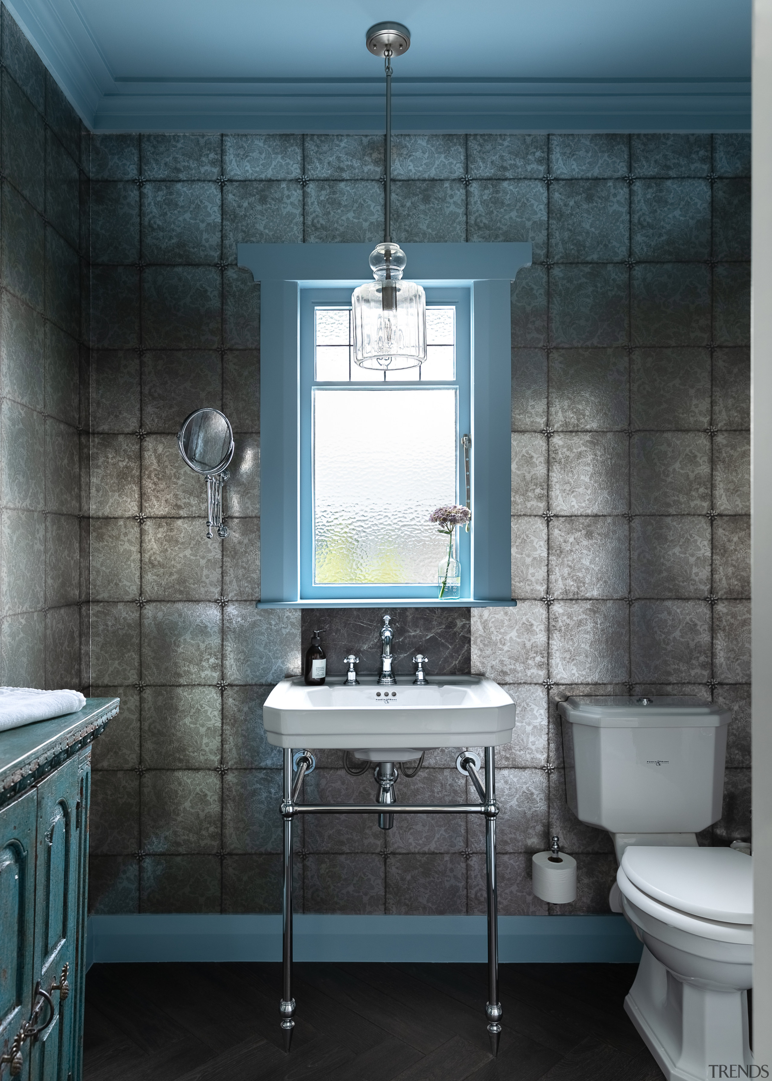 The powder room, with wallpapered walls and blue 