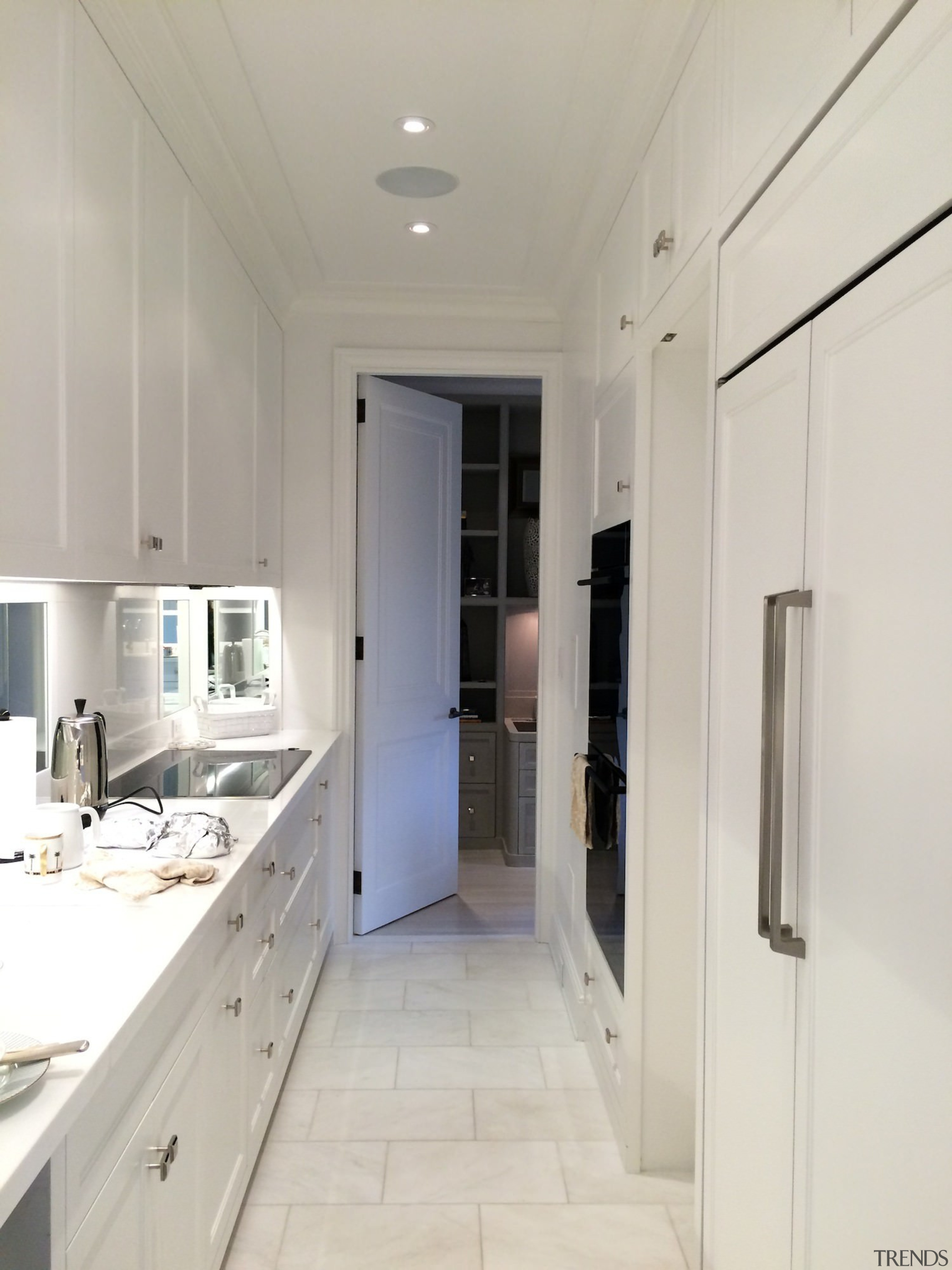 A long, narrow kitchen features ample work space countertop, floor, interior design, kitchen, property, real estate, room, gray