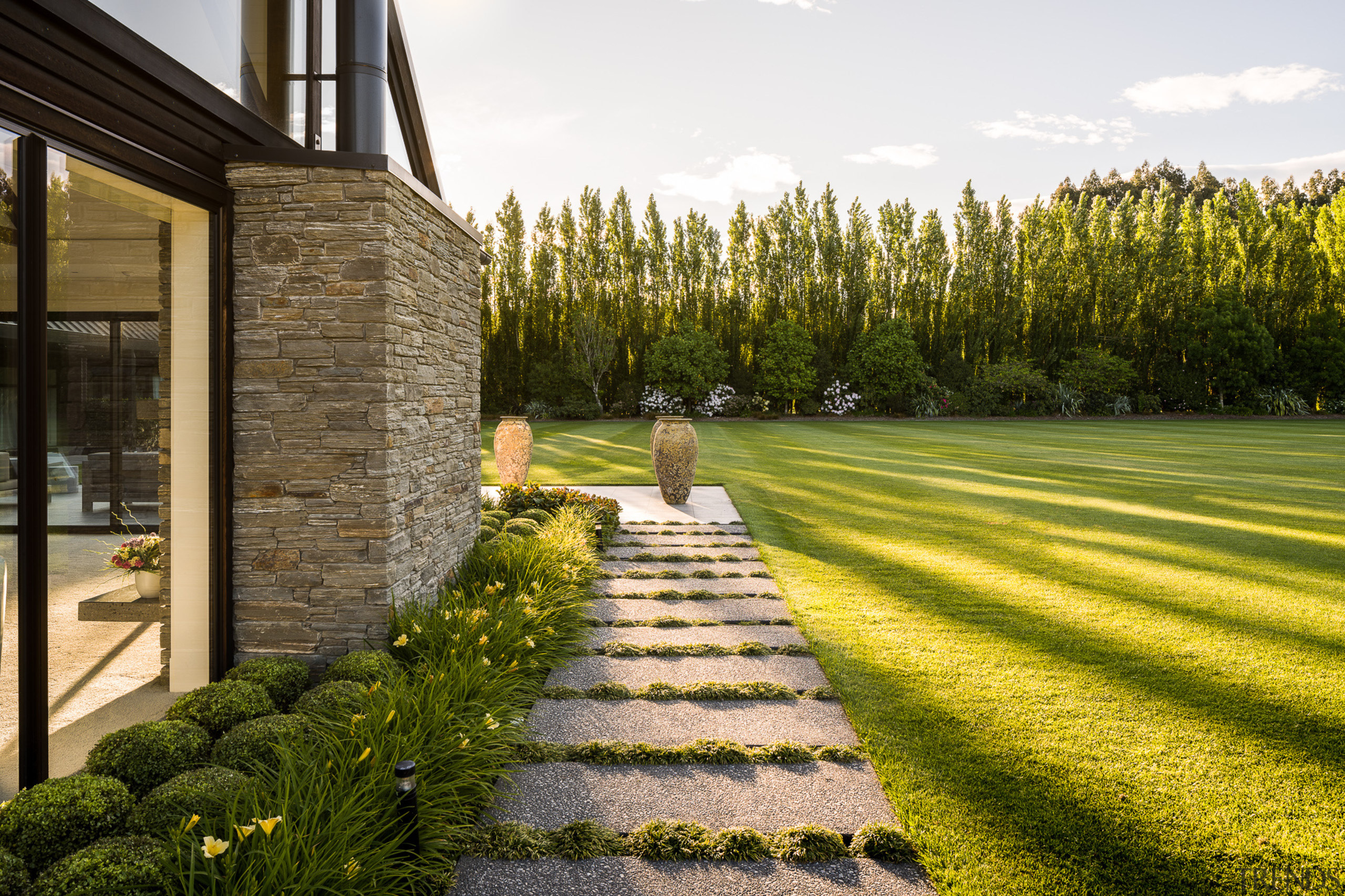 Pavers with plantings between run alongside the schist 