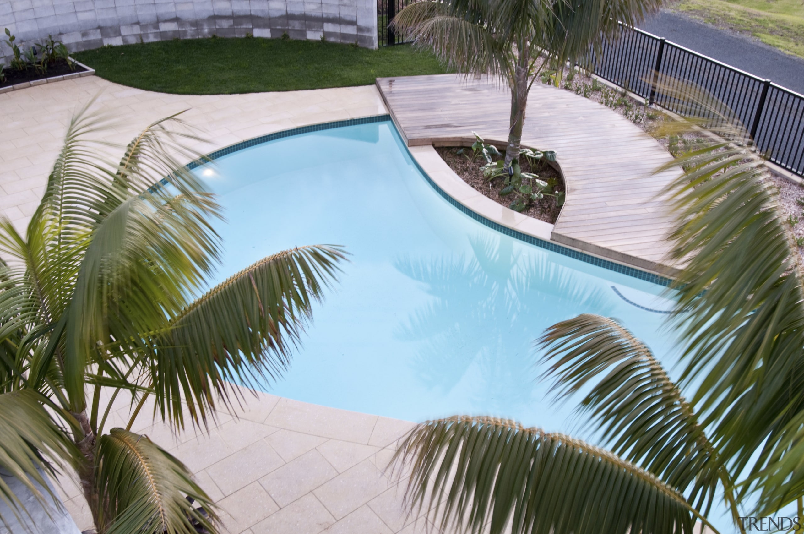 View of a resort-styled pool which was built arecales, backyard, estate, house, leisure, palm tree, plant, property, real estate, reflection, resort, swimming pool, vacation, water, gray