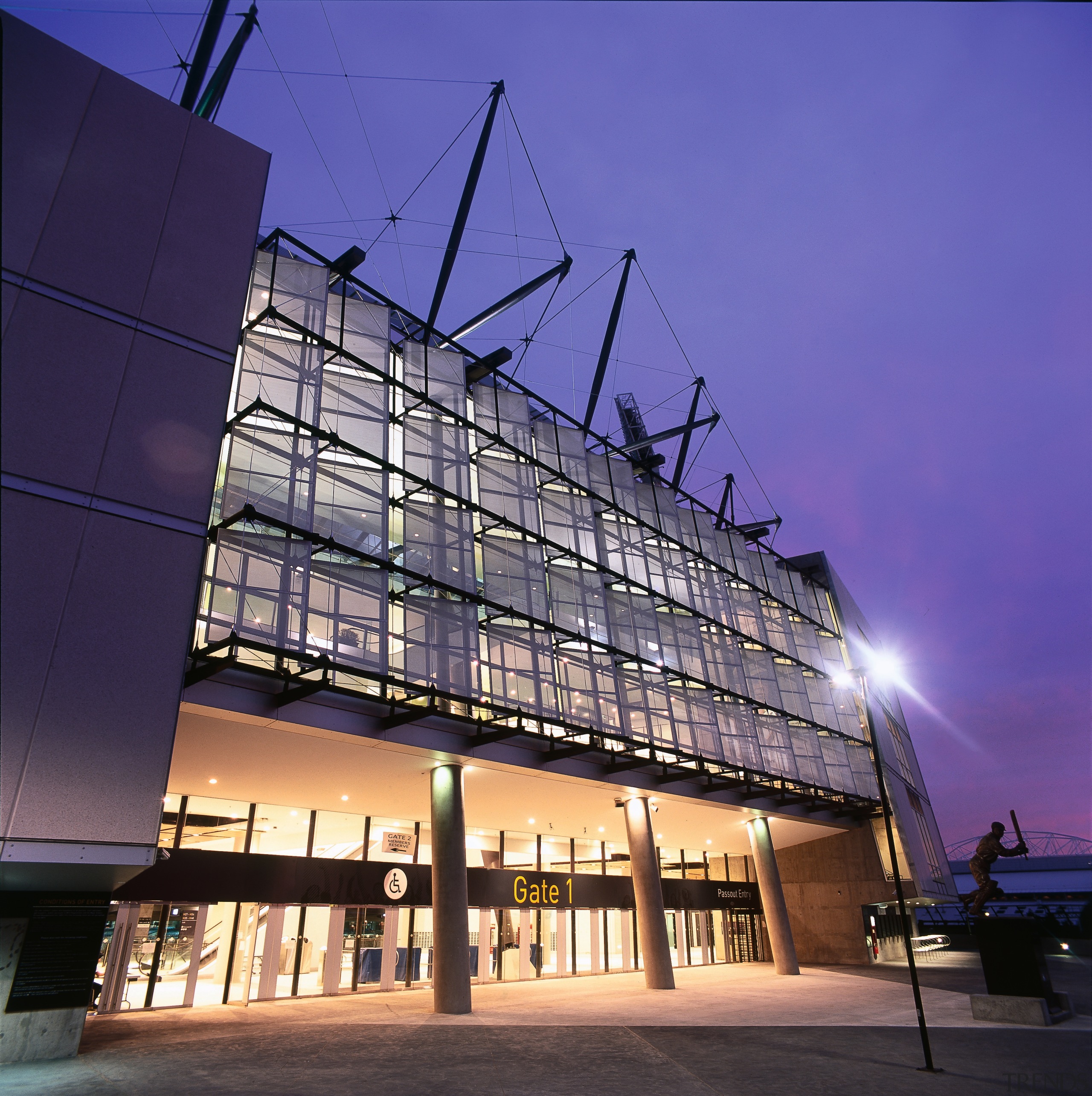 Exterior view of MCG stadium showing lighting. - architecture, building, commercial building, condominium, convention center, corporate headquarters, daylighting, evening, facade, headquarters, landmark, metropolis, metropolitan area, mixed use, night, reflection, residential area, sky, structure, tourist attraction, blue, purple