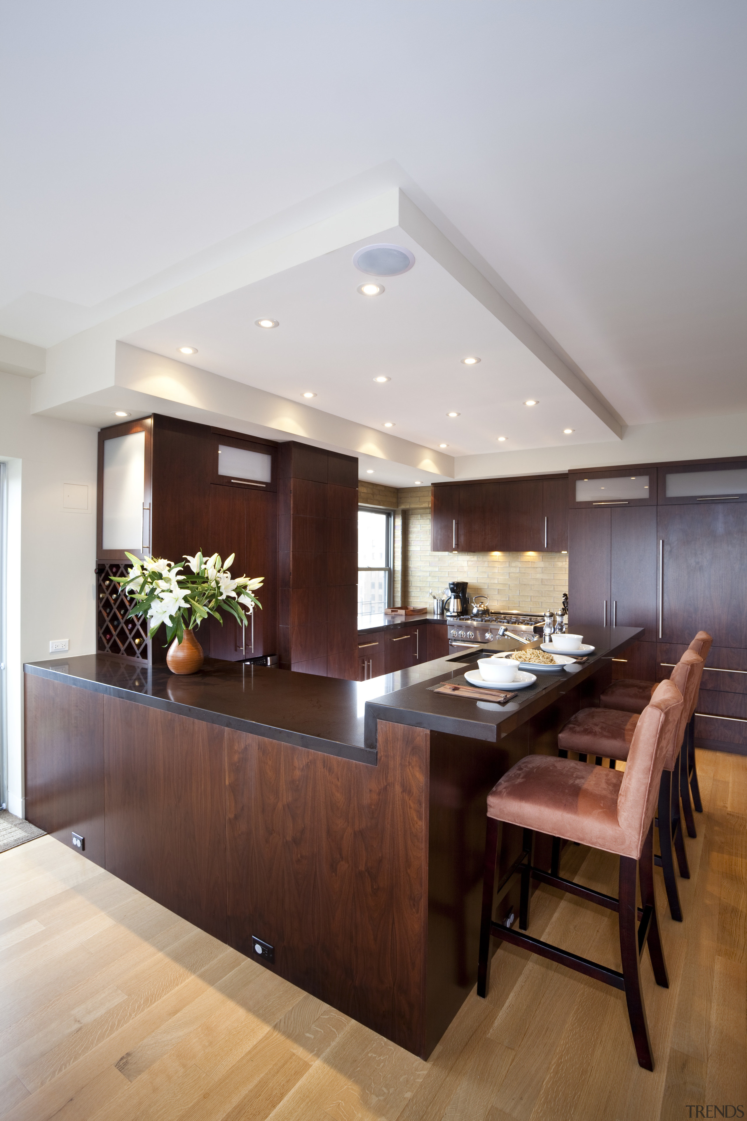 Dark wooden cabinetry, dark coloured benchtop, white walls ceiling, countertop, floor, flooring, hardwood, interior design, kitchen, living room, room, table, wood flooring, gray