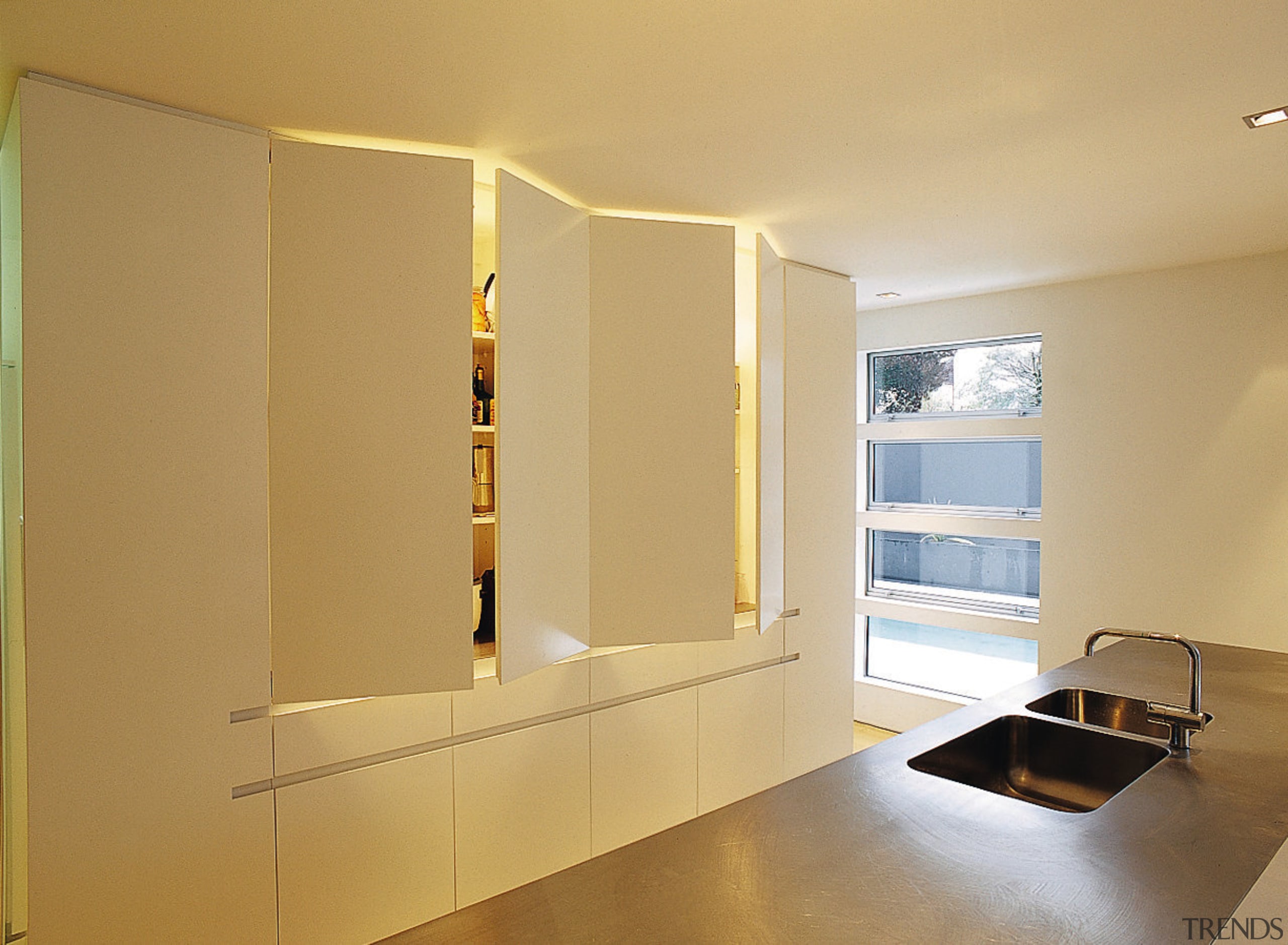 An interio view of the kitchen featuring timber cabinetry, floor, home, interior design, light fixture, lighting, room, shelf, wall, orange