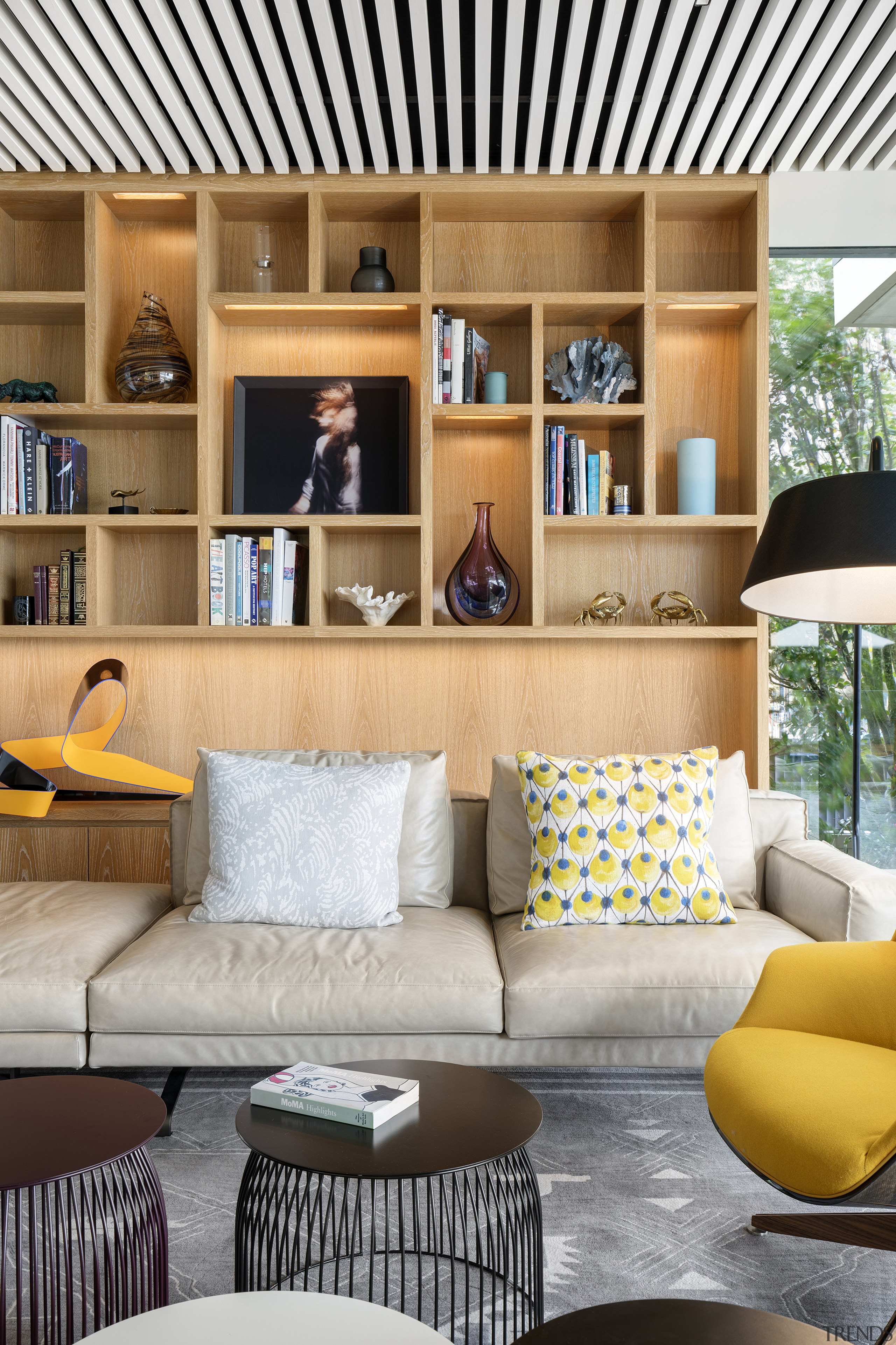 ​​​​​​​This family living area in front of the bookcase, couch, furniture, home, interior design, living room, room, shelf, shelving, table, wall, white, SAOTA