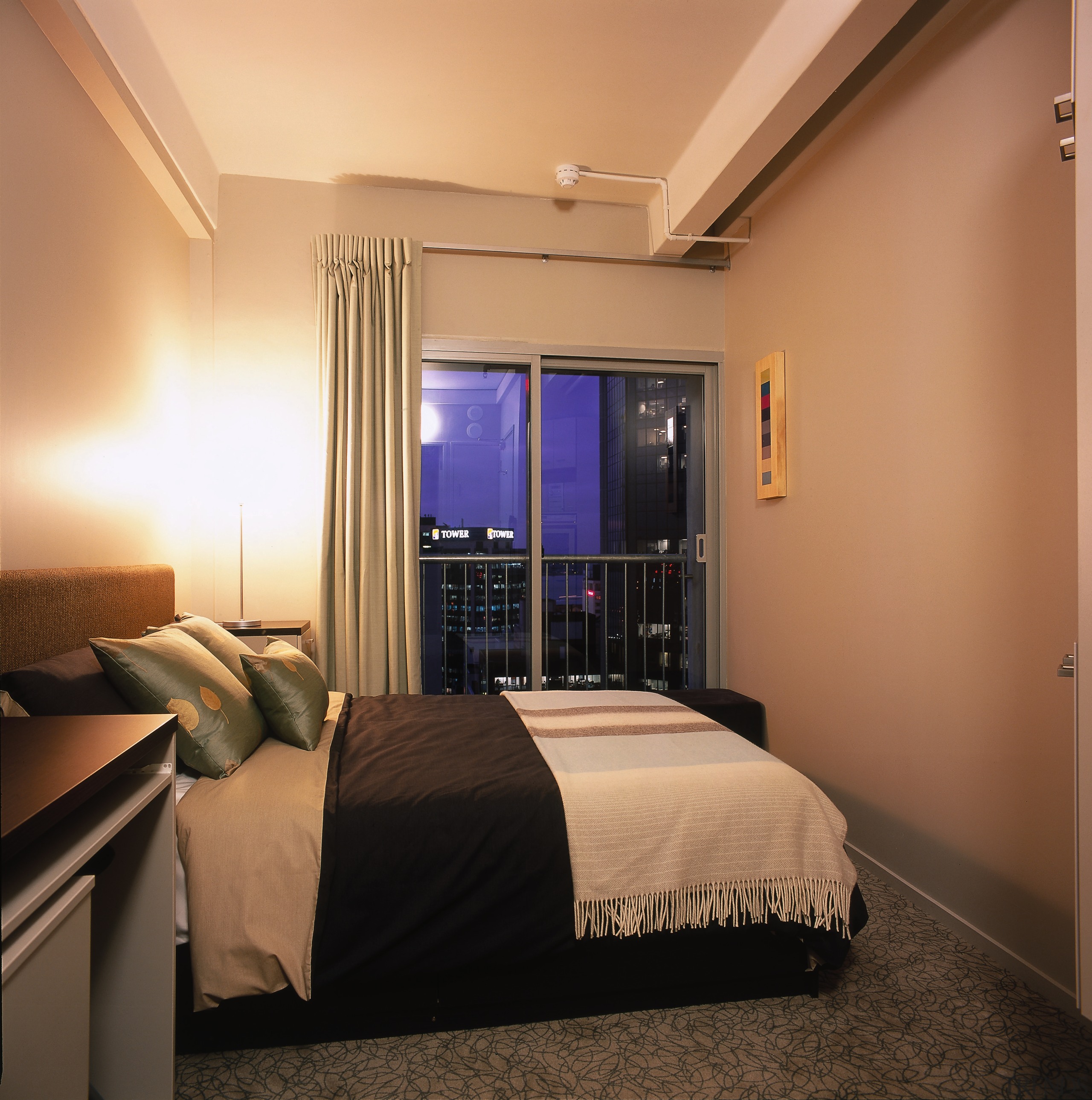 View of studio bedroom with natural coloured walls, bed frame, bedroom, ceiling, home, interior design, lighting, real estate, room, suite, wall, orange, brown