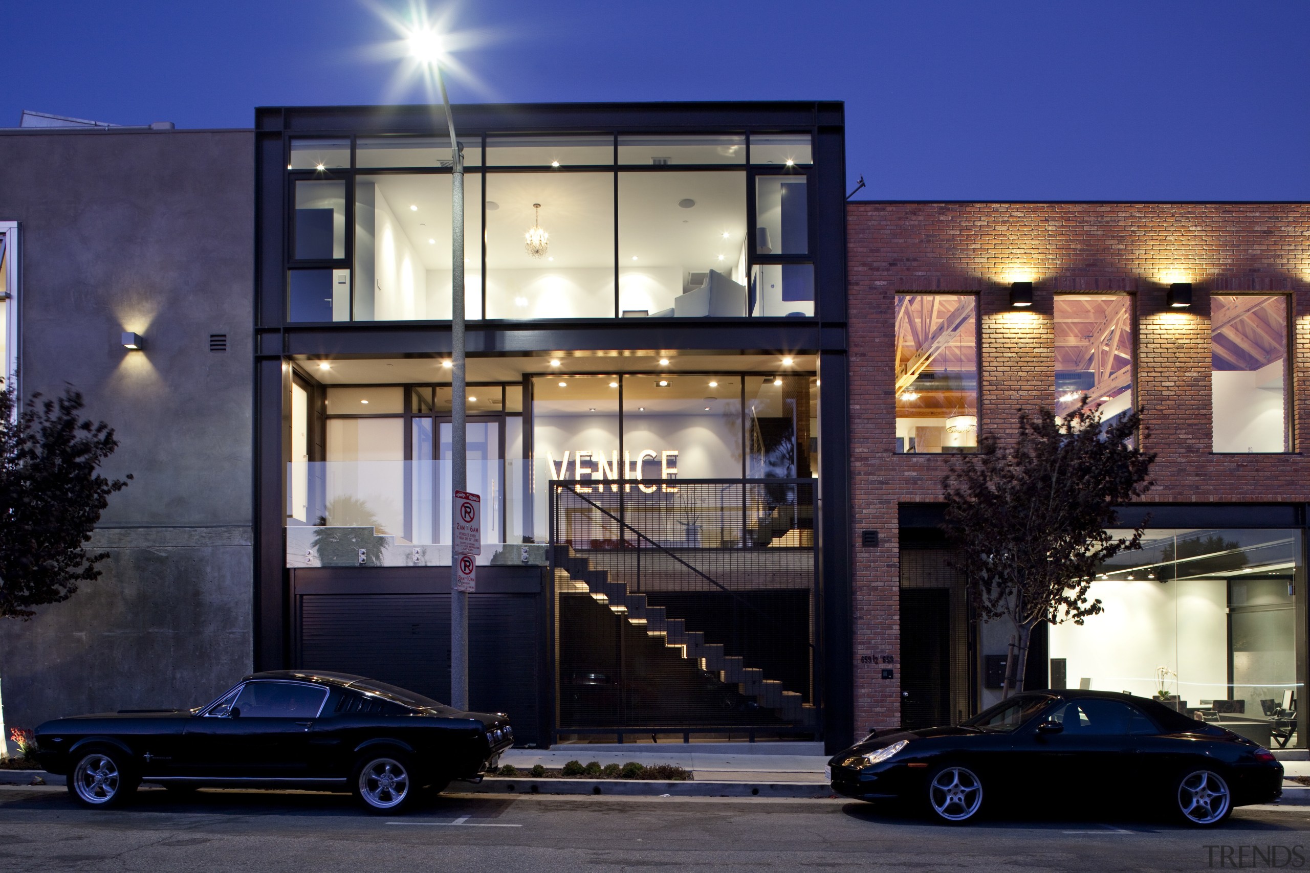 Exterior night view of contemporary building. - Exterior architecture, building, car, facade, family car, home, house, luxury vehicle, mixed use, night, real estate, residential area, window, blue, black