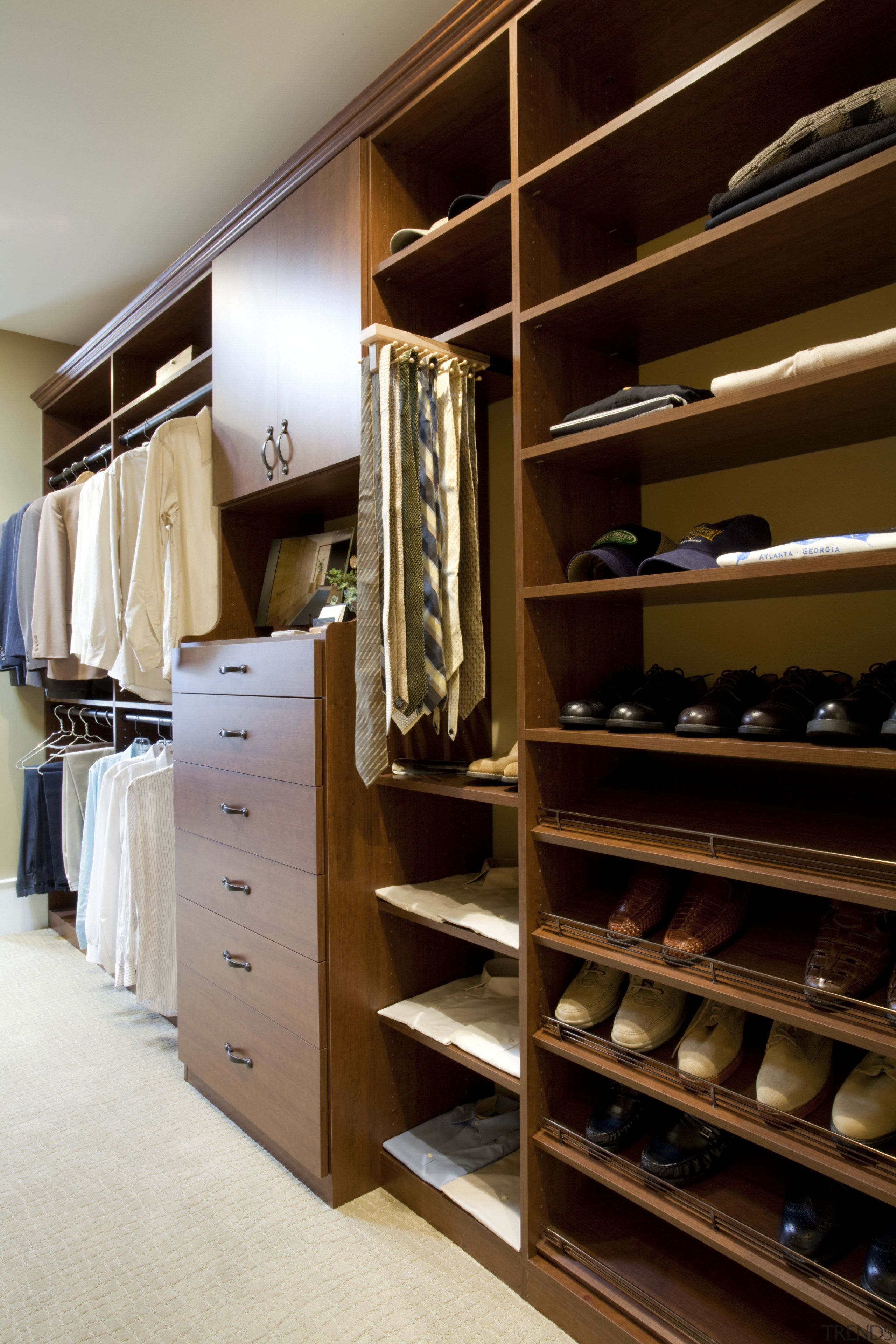 View of walk-in closet featuring shelving and storage. cabinetry, closet, furniture, room, wardrobe, black, brown