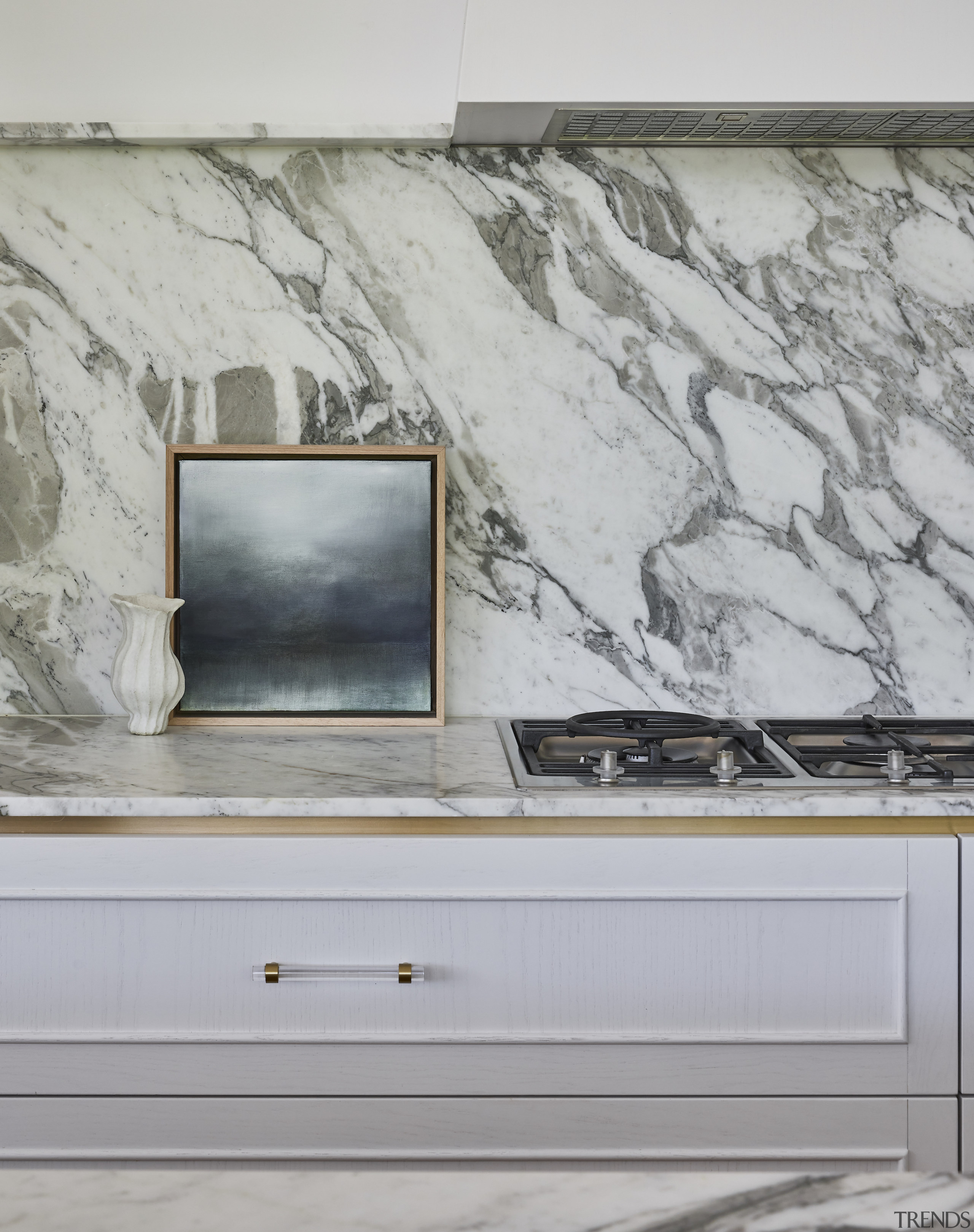 The slender perimeter benchtop turns up the wall 