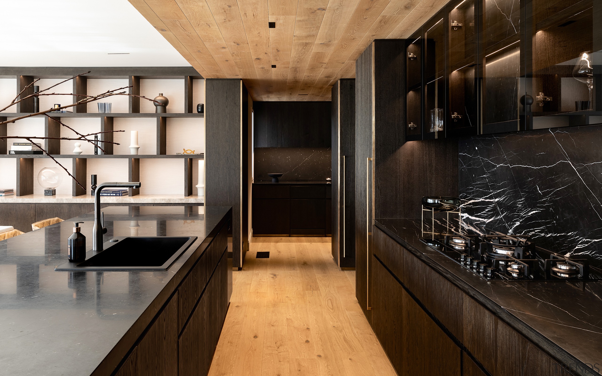 The dark-toned kitchen cabinetry finds a material echo 