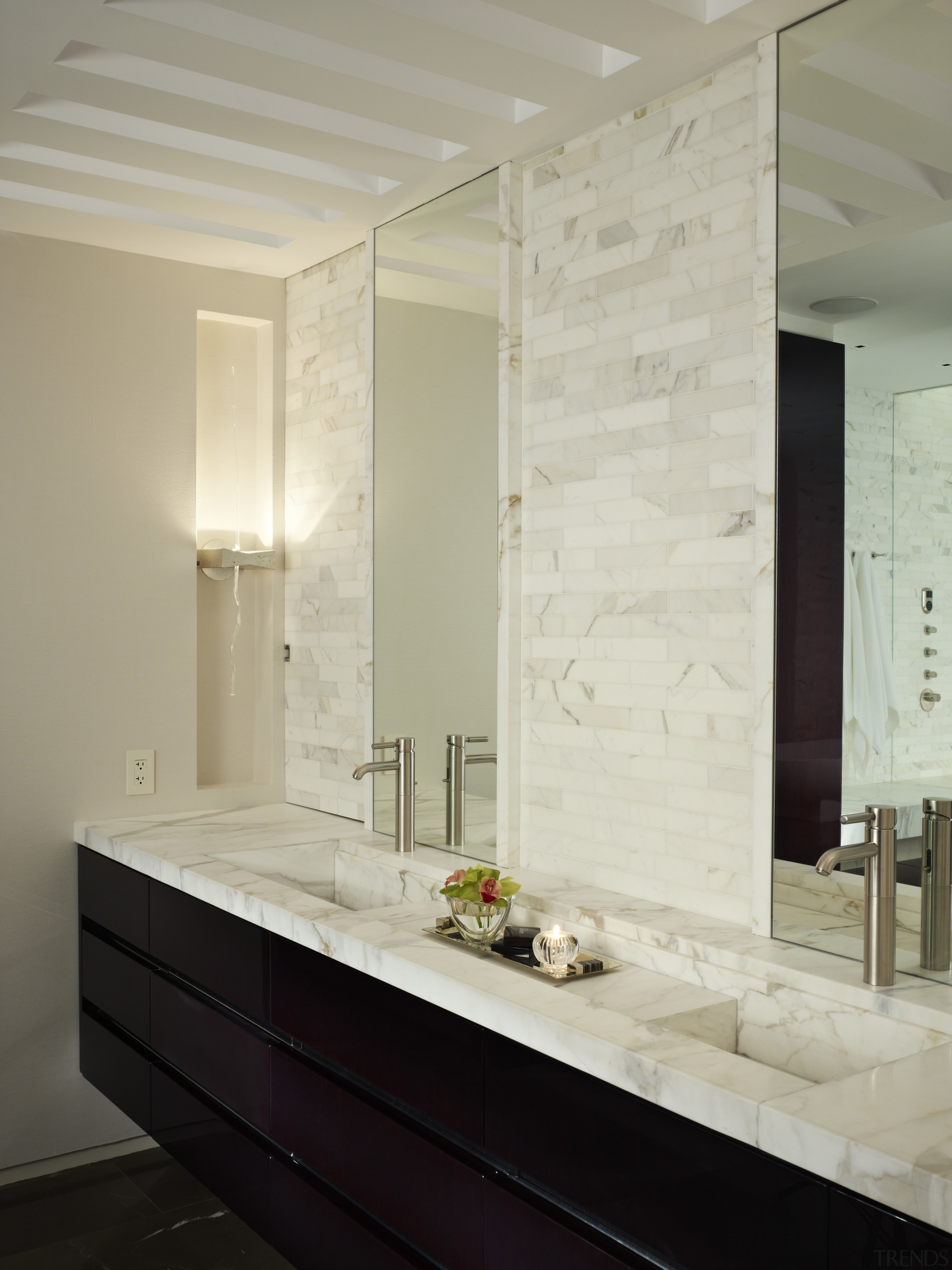 A high-gloss, ebonized walnut vanity contrasts the white bathroom, countertop, floor, flooring, interior design, room, sink, tile, wall, gray