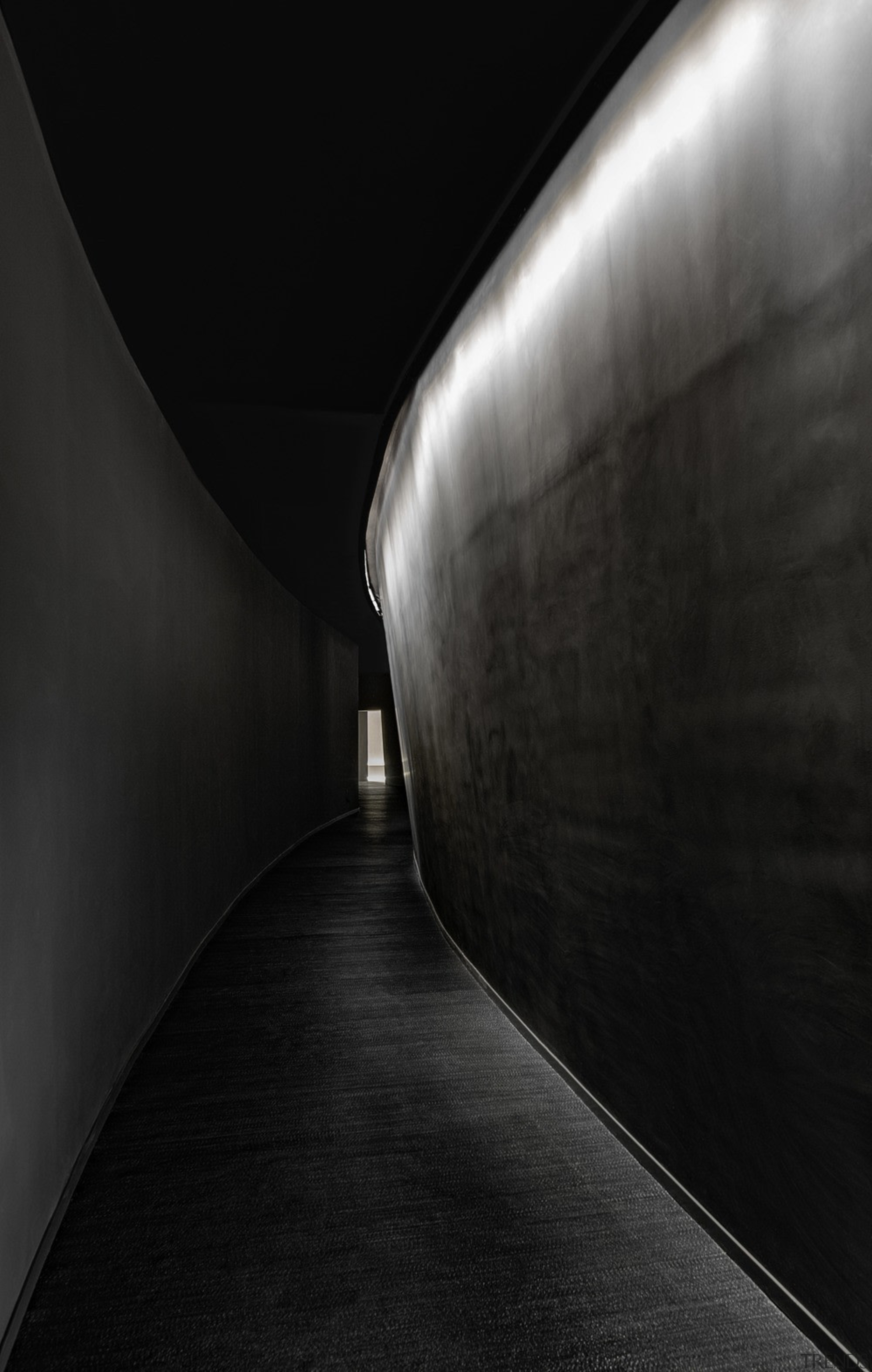 In this theatre design, a dark curved corridor angle, architecture, atmosphere, black, black and white, darkness, daylighting, fixed link, infrastructure, light, line, monochrome, monochrome photography, photography, reflection, symmetry, black