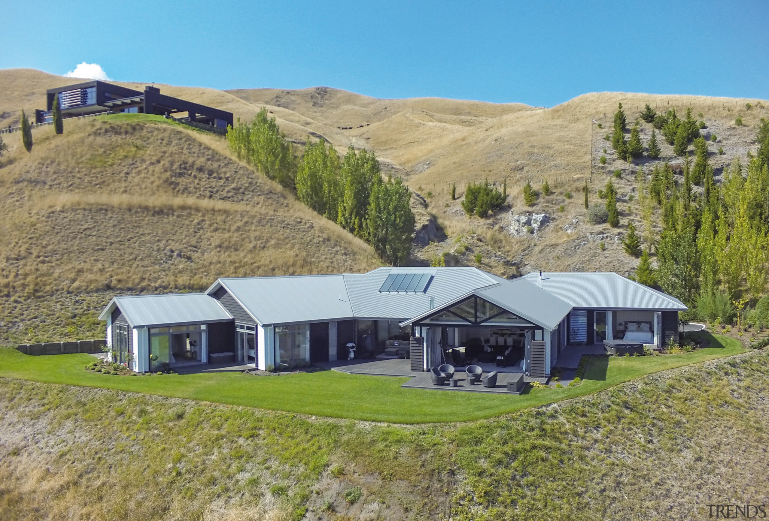 This custom-designed home by GJ Gardner Homes features cottage, estate, farm, farmhouse, grassland, highland, hill, home, house, hut, land lot, landscape, property, real estate, rural area, brown