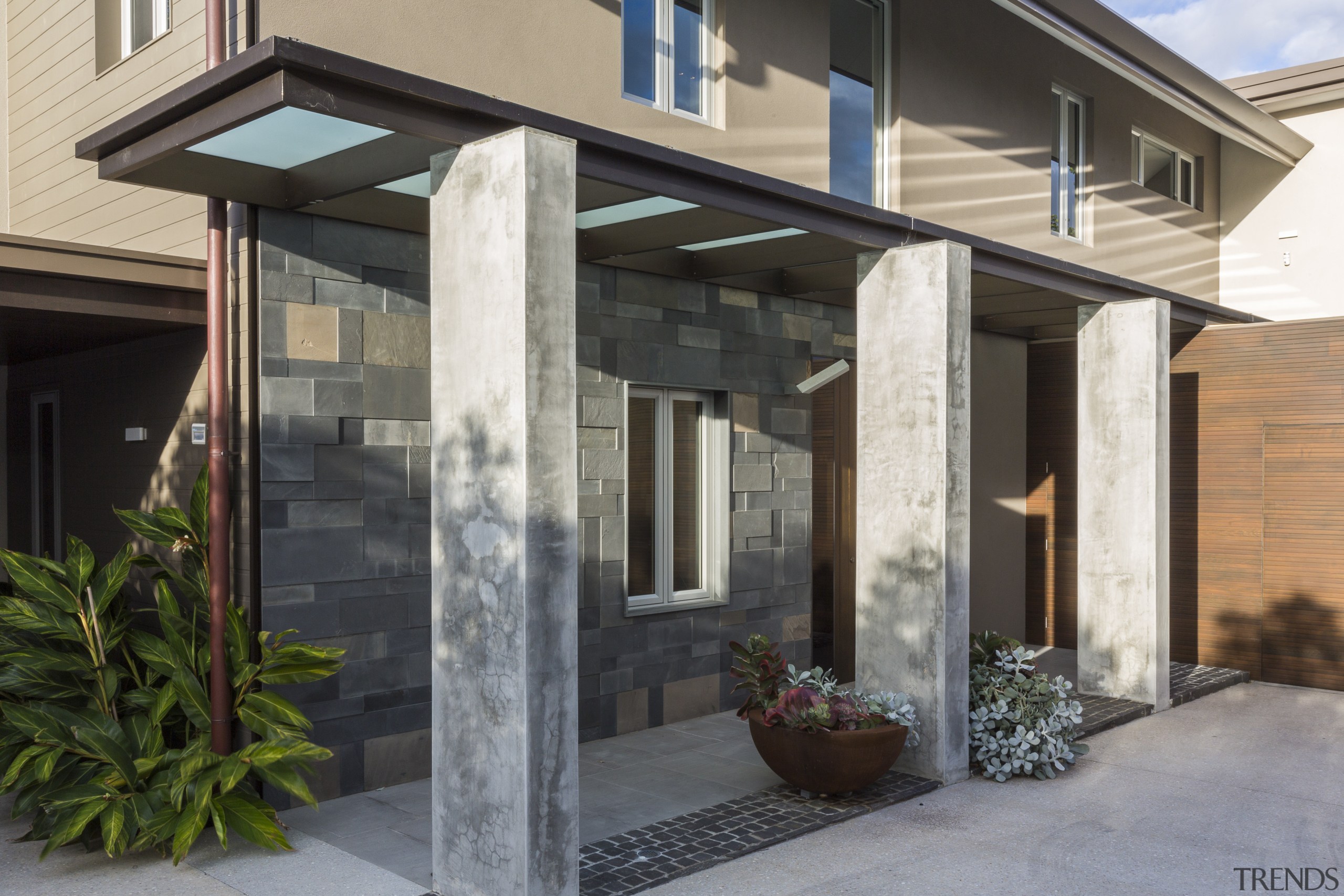 The main entrance to this renovated house is door, facade, home, house, porch, real estate, residential area, siding, window, black, gray