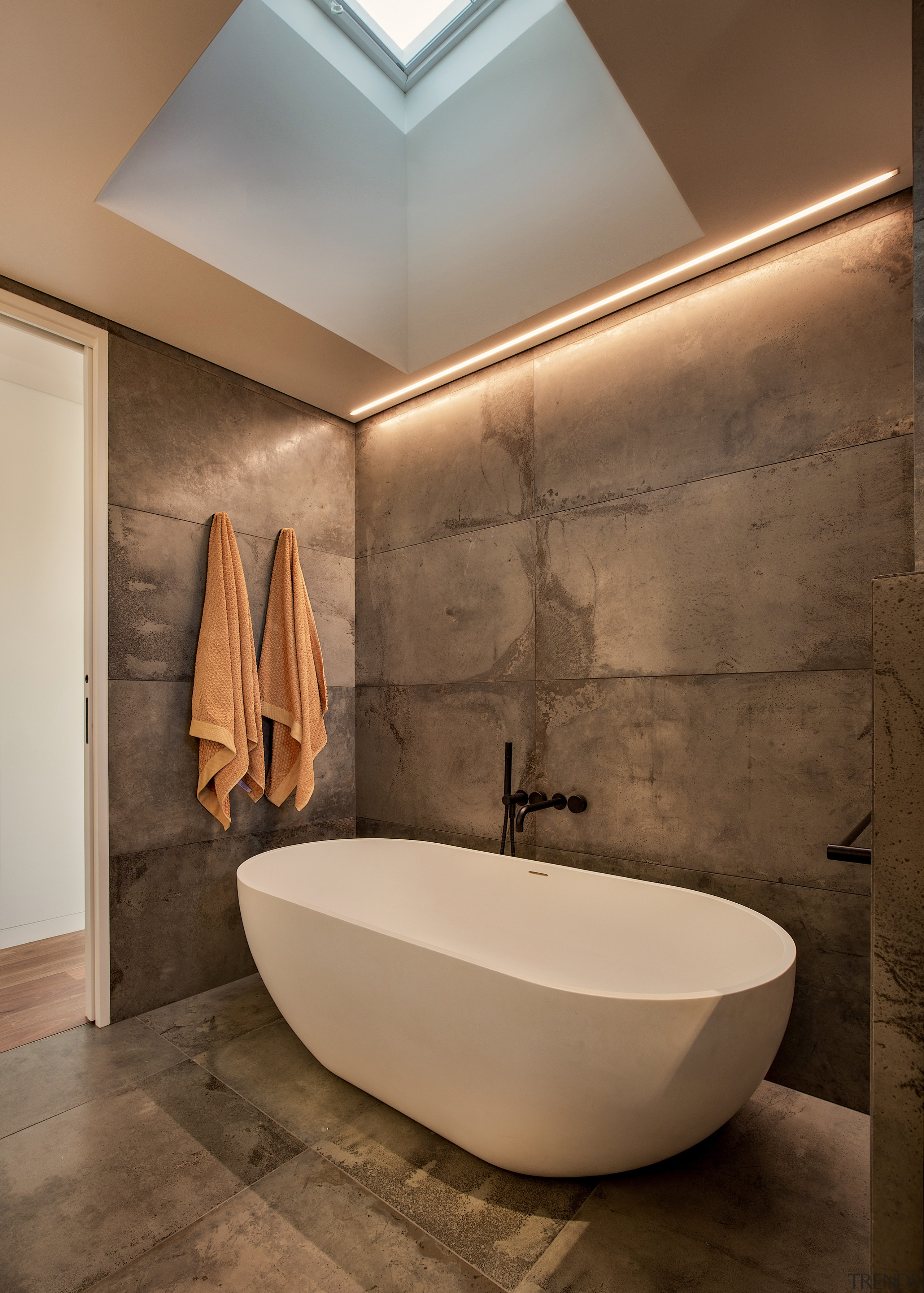 A large skylight above the bathtub floods the 