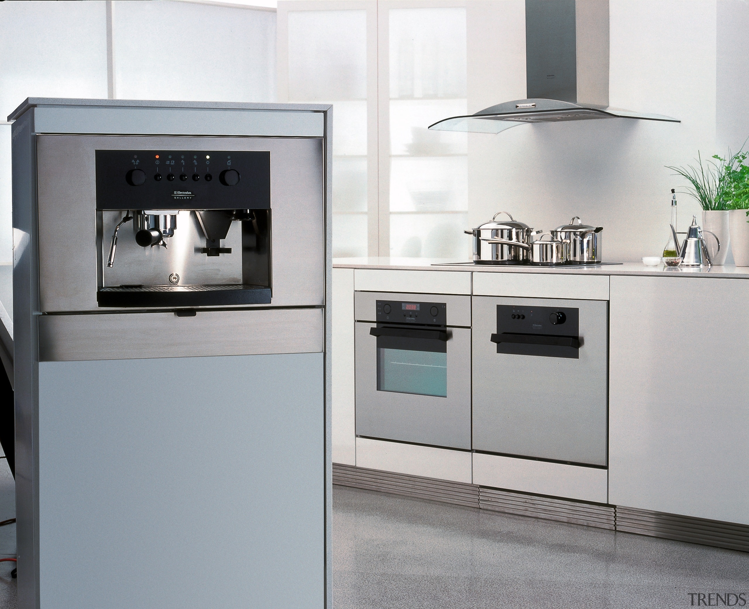 A photograph of a European styled kitchen. The gas stove, home appliance, kitchen, kitchen appliance, kitchen stove, major appliance, oven, product, product design, refrigerator, small appliance, gray, white