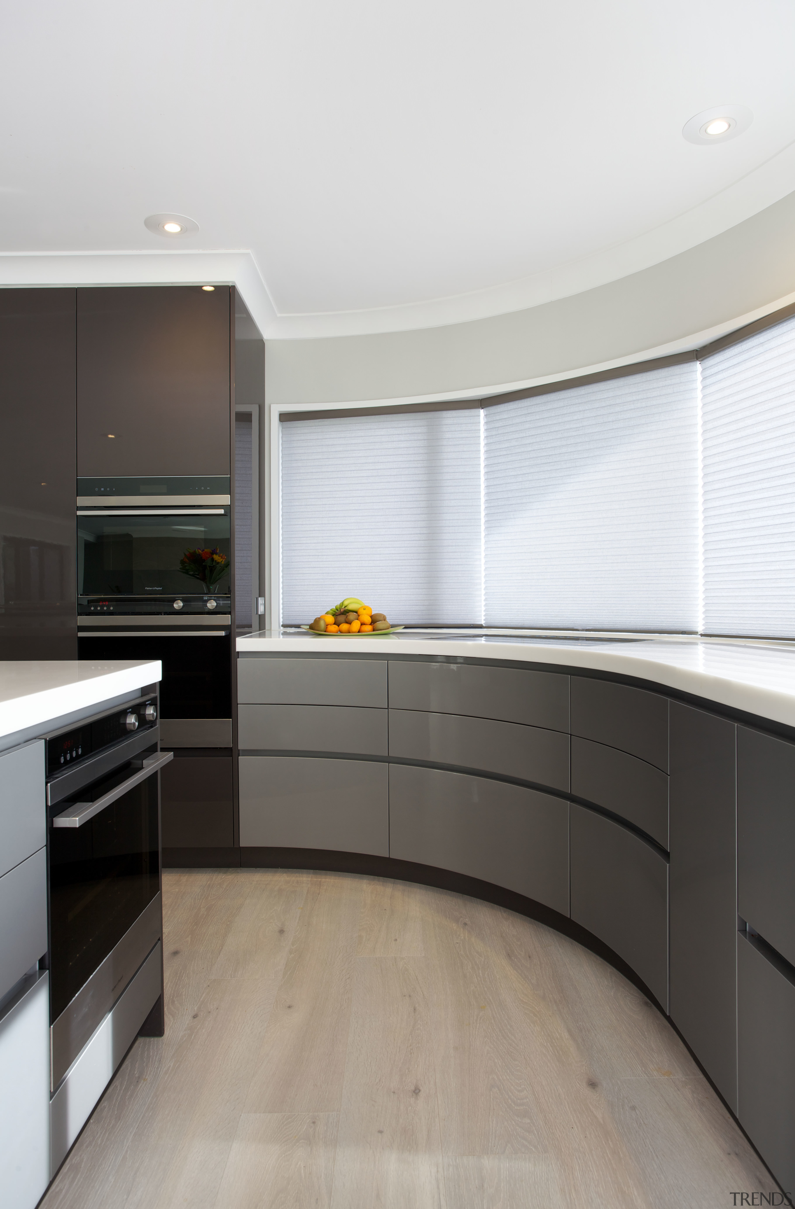 High-gloss metallic lacquered cabinetry features in this new cabinetry, countertop, cuisine classique, floor, flooring, hardwood, interior design, kitchen, room, wood flooring, gray, white